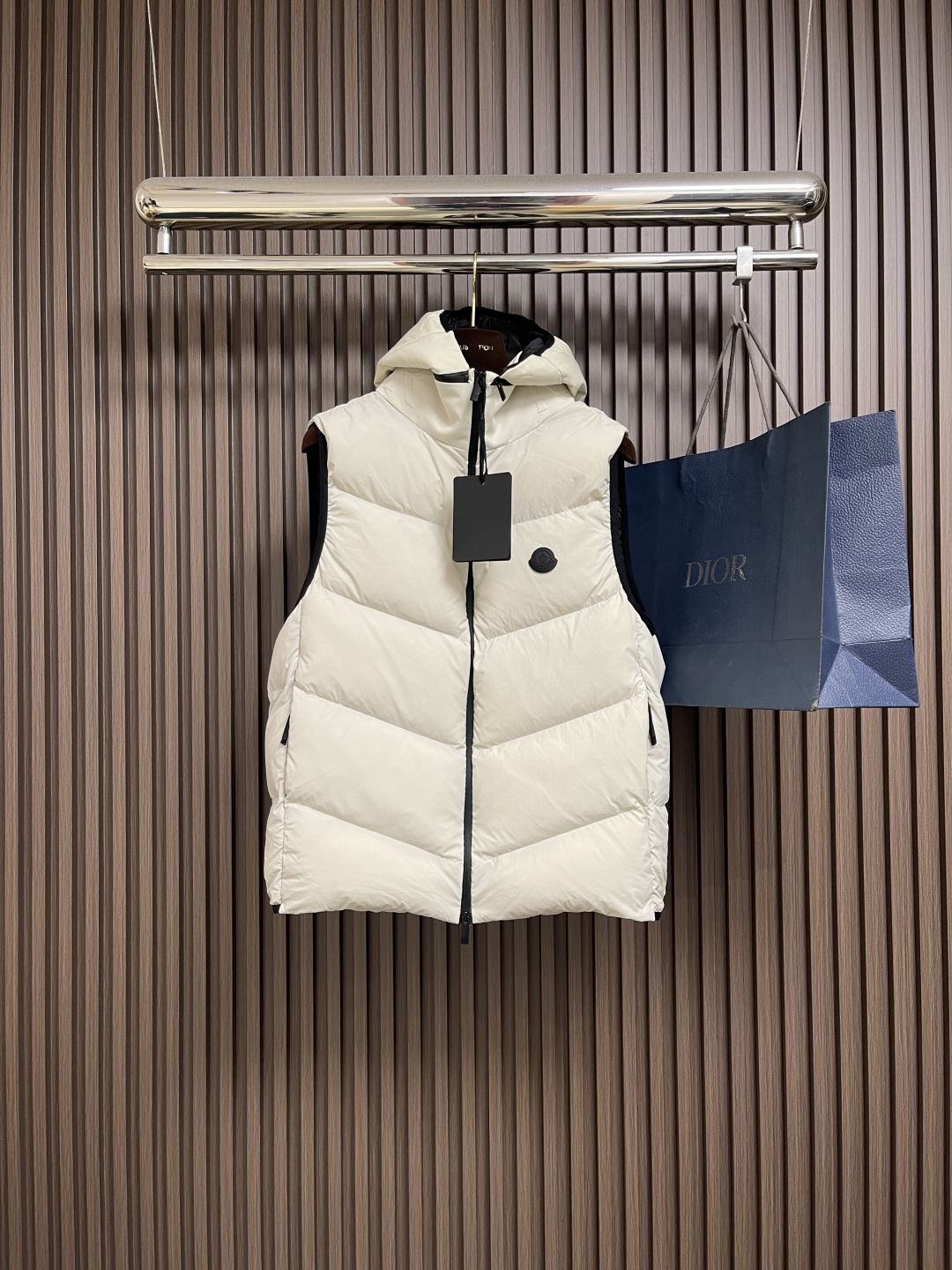 NO:569821,Moncler  The crested hooded down vest is made of nylon fabric made of nylon. It is woven into a tight and tough fabric through advanced textile technology. It improves the strength of the skeleton, effectively blocks the invasion of cold wind, and locks in the warm air generated by the down layer. After a tight weaving process and special treatment, it is waterproof and windproof. The surface forms a certain lotus leaf effect. It is also wrinkle-resistant and not easy to deform, making it easy for daily care.  .The quilting stitches are sewn in a diagonal direction at an angle of about 70 degrees. The diagonal lines are arranged in parallel. The fabric and filling are planned into different functional areas. The quilting stitches in each area are relatively independent. This allows the finished product to produce a larger deformation space along the diagonal direction when stretched and pressed, which is not easy to tighten and break, and has rich visual effects, modern and advanced. Sizes 1-2-3-4,,down  jacket,hats,alexander wang19860909Moncler 饰章连帽羽绒马甲,选用锦纶制成的尼龙面料,通过先进的纺织技术,编织成紧密且坚韧的布料,提升骨架强度有效阻挡冷风侵袭,锁住羽绒层产生的暖空气,经过紧密的编织工艺和特殊处理之后使其具备防水防风等功能,表面形成一定的荷叶效应,同时抗皱不易变形,易于日常打理.绗缝缝线以大约70度角的斜线方向进行缝制,斜线平行排列,面料和填充物被规划成不同功能区域,每个分区内绗缝线迹相对独立.使得成品在拉伸和压力时,能沿着斜线方向产生更大的形变空间,不易绷紧和断裂,且视觉效果丰富,现代又高级.尺码1-2-3-4,,down jacket,hats,alexander wang,Men's clothing