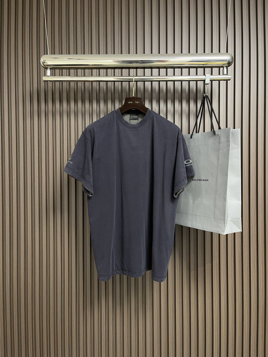 NO:573307,Balenciaga front and back double-layered round neck short-sleeved T-shirt   The main body is made of 24S plain knitted fabric with a weight of 185g; with 32S double yarn 1*1 thread, the weight is 270g. The fabric weight ensures lightness and breathability. The 24-count yarn gives the fabric a delicate and smooth texture, and the plain knitted structure brings good skin-friendly feel and moderate elasticity. The fabric has been washed in faded gray, which not only gives it a unique retro appearance but also softens the color.  Color, and also achieves a pre-softening effect on the touch, eliminating the stiffness of the new fabric, so that the ready-made garments present a comfortable and soft old material texture when worn for the first time. The main body of the gray surface embroidery adopts new tatami twill lace embroidery, and the tatami embroidery stitches are interwoven with each other to form diagonal lines. The tatami woven surface and the shaped edge integrally connected with the tatami woven surface have good flatness, soft hand feel, good elasticity and gloss.  Good. The woven surface of the tatami is indented compared to the fixed edge, which improves the three-dimensional effect of the pattern and has a better visual effect. The black surface adopts precision needle embroidery technology; the embroidery is very fine and dense, the pattern is clear and the lines and three-dimensional sense are strong. The linen material embroidery thread is densely processed, and the embroidery body has a subtle matte visual texture; the embroidery effect is three-dimensional and full. The flat embroidery has a unique stitching design, and the embroidery is very fine and dense; the overall needlework  The feet are fine and the fineness and texture are consistent, adding a sense of layering to the simple design. A unique technology that simulates natural aging through the post-finishing process. Through controlled stone grinding, enzyme washing and other processes, the original dye in the cotton fiber is partially removed, forming uneven fading marks on the dark base, thereby creating a soft, retro grayscale visual effect. The overall wiring is straight and delicate, the fabric is comfortable and soft, and the color is consistent without color difference.   It can be matched with the same style to create a fashionable look, and can be used in various occasions. Customized accessories, complete with three standards, same style for men and women!  Size XS-L,,balenciaga,T-shirt,tees,t-shirt,alexander wang19860909Balenciaga 正反双层圆领短袖T恤 主体采用24S平纹针织面料克重为185g；搭配32S双纱1*1螺纹,克重为270g.面料克重确保了穿着的轻盈与透气性.24支纱线赋予了面料细腻平整的肌理,平纹针织结构则带来了良好的亲肤感和适度的弹性.面料经过褪色灰色水洗处理,这不仅赋予其独特的复古外观,柔和了色彩,更在触感上实现了预软化的效果,消除了新织物的生硬感,使成衣初次穿着即呈现舒适柔软的旧物质感.灰色面刺绣主体采用新型榻榻米斜纹花边刺绣,榻榻米绣花针法相互交织而成并形成斜向纹路.榻榻米编织面、及与榻榻米编织面一体连接的定型边.平整性好,手感柔软,弹性好,光泽度好.榻榻米编织面相较定型边内陷,提高花纹的立体感,视觉效果更好.黑色面采用精密挨针绣工艺；刺绣非常精细针法绵密,图案清晰且线条感和立体感强.亚麻材质绣线合加密处理,绣体具有微妙的哑光视觉质感；刺绣效果立体饱满.平绣的挨针走线独特设计,刺绣非常精细针法绵密；整体针脚细密,精细度质感一致,为简约设计增添了层次感.通过后整理工艺模拟自然旧化感的独特技术.通过控制性的石磨、酶洗等工艺,部分去除棉纤维中的原身染料,在深色基底上形成不均匀的褪色痕迹,从而营造出柔和、复古的灰度视觉效果.整体走线平直细腻,面料舒适柔软,颜色一致无色差 能与同款搭配营造时尚造型,驾驭各种场合,定制辅料,三标齐全,男女同款！尺码XS-L,,balenciaga,T-shirt,tees，t-shirt,alexander wang,Men's clothing