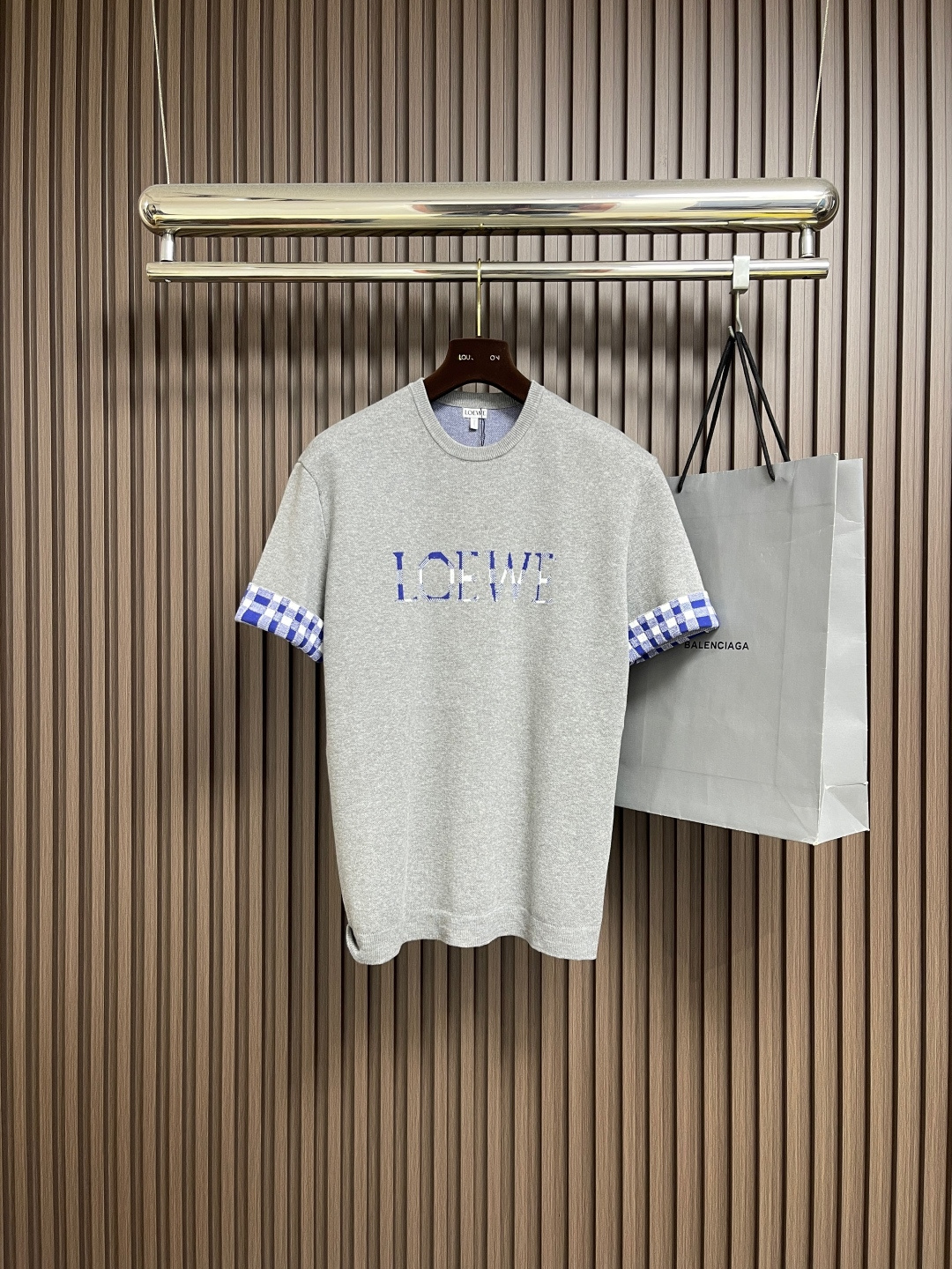 NO:572176,loewe 2025fw checkerboard pattern turned-sleeve woolen short-sleeved T-shirt, blended wool and cotton wool main body, using wool and cotton blended yarn, processed by 12S knitting jacquard machine  Using the tiny dot-like texture of sesame bottom jacquard as the base, a unique micro-texture is formed on the surface of the fabric, which not only increases the visual level, but also makes the touch delicate and plump. The jacquard pattern is the design of this product, thus weaving a complex pattern with clear patterns and rich details. The front brand logo and plaid pattern are directly formed by yarns of different colors in the weaving process. Sizes XS-L, loewe, T-shirt, tees, t-shirt, alexander  wang19860909loewe 2025fw 棋盘格纹翻袖毛织短袖T恤,混纺羊毛棉质毛织主体,采用羊毛与棉混纺的纱线,12S针织提花机处理 通过芝麻底提花这种细小的点状纹理作为基底,面料表面形成了独特的微肌理,不仅增加了视觉层次,更使触感细腻丰盈毛织提花工艺设计,提花图案是本品的设计,从而织出图案清晰、细节丰富的复杂花纹.正面品牌标识与格纹图案均,直接由不同颜色的纱线在织造过程中一体成型.尺码XS-L,,loewe,T-shirt,tees，t-shirt,alexander wang,Men's clothing