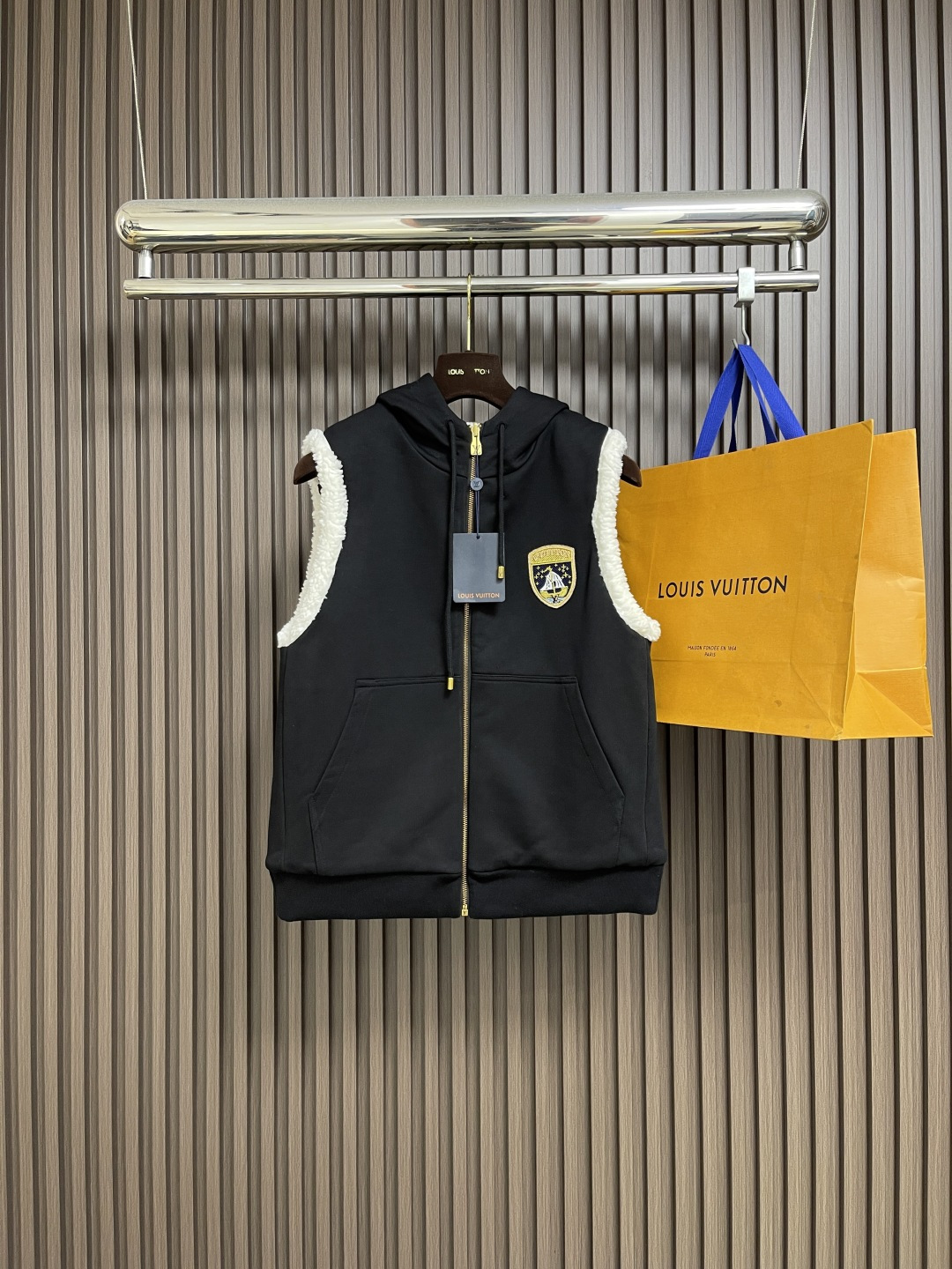 NO:573313,LV  The embroidered double-sided hooded vest uses a flip design of cotton knitted surface and comfortable suede surface. It adopts advanced double-sided weaving and composite technology to perfectly integrate the two materials and make the transition natural when switching. The shield logo patch adopts high-precision patching technology, with neat edges and clear and vertical patterns.  The body; the embroidered logo on the back uses fine embroidery technology, with fine and even stitches, perfectly integrating the logo into the back design; the drawstring hood uses high-quality drawstrings and precision sewing technology, which not only ensures the adjustment function of the hood, but also enhances the overall casual feel. Sizes S-XL, Louis  vuitton,hats,alexander wang19860909LV 刺绣双面穿连帽马甲,采用棉质针织面与舒暖绒面的翻转设计极具巧思,采用先进的双面织造与复合工艺,使两种材质完美融合,切换时过渡自然；盾徽标识贴饰采用高精度贴布工艺,边缘整齐,图案清晰立体；后部刺绣标识运用精细的刺绣工艺,针脚细密均匀,将标识完美融入背部设计；抽绳兜帽采用高品质抽绳与精密缝制工艺,既保证了兜帽的调节功能,又提升了整体的休闲感.尺码S-XL,,louis vuitton,hats,alexander wang,Men's clothing