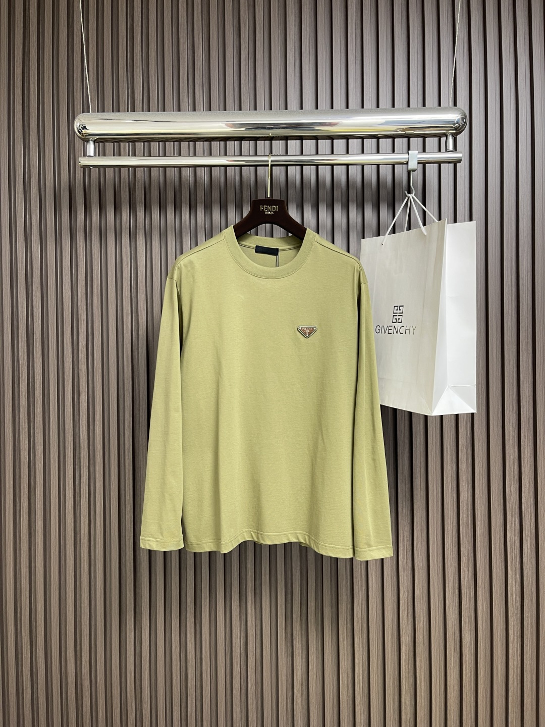 NO:651461,Prada  The new 2025 SS autumn and winter avocado green long-sleeved T-shirt has a lazy and high-end feel with one click. It is made of skin-friendly fabrics of 99% cotton + 1% polyester fiber, which is soft and breathable yet stiff and stylish, and is comfortable to wear close to the body. The iconic triangle logo on the chest, with the texture of leather and metal, low-key highlights the brand recognition, letting the 'high-end sense' quietly reveal in the details. Lazy oversi  The ze version is friendly to all body shapes, and couples can easily create a harmonious outfit when worn together. Whether worn alone to highlight a casual tone, or layered to create a layered style, this avocado green can make you stand out in autumn outfits and become the most eye-catching fashionable CP on the street! Sizes S-M-L, prada, versace, tees, t-shirt, alexander  wang19860909Prada 2025SS秋冬新款牛油果绿长袖T恤,慵懒高级感一键拉满.选用99％棉＋1％聚酯纤维的亲肤面料,柔软透气却又挺括有型,贴身穿着舒适感拉满；胸前标志性的三角徽标,以皮革与金属的质感碰撞,低调彰显品牌辨识度,让'高级感'在细节处悄然流露.慵懒的oversize版型对各种身形友好,情侣同穿轻松打造默契穿搭.不管是单穿凸显随性腔调,还是内搭叠出层次风格,这抹牛油果绿都能带你在秋日穿搭中脱颖而出,成为街头最吸睛的时髦CP!尺码S-M-L,,prada,versace,tees，t-shirt,alexander wang,Men's clothing