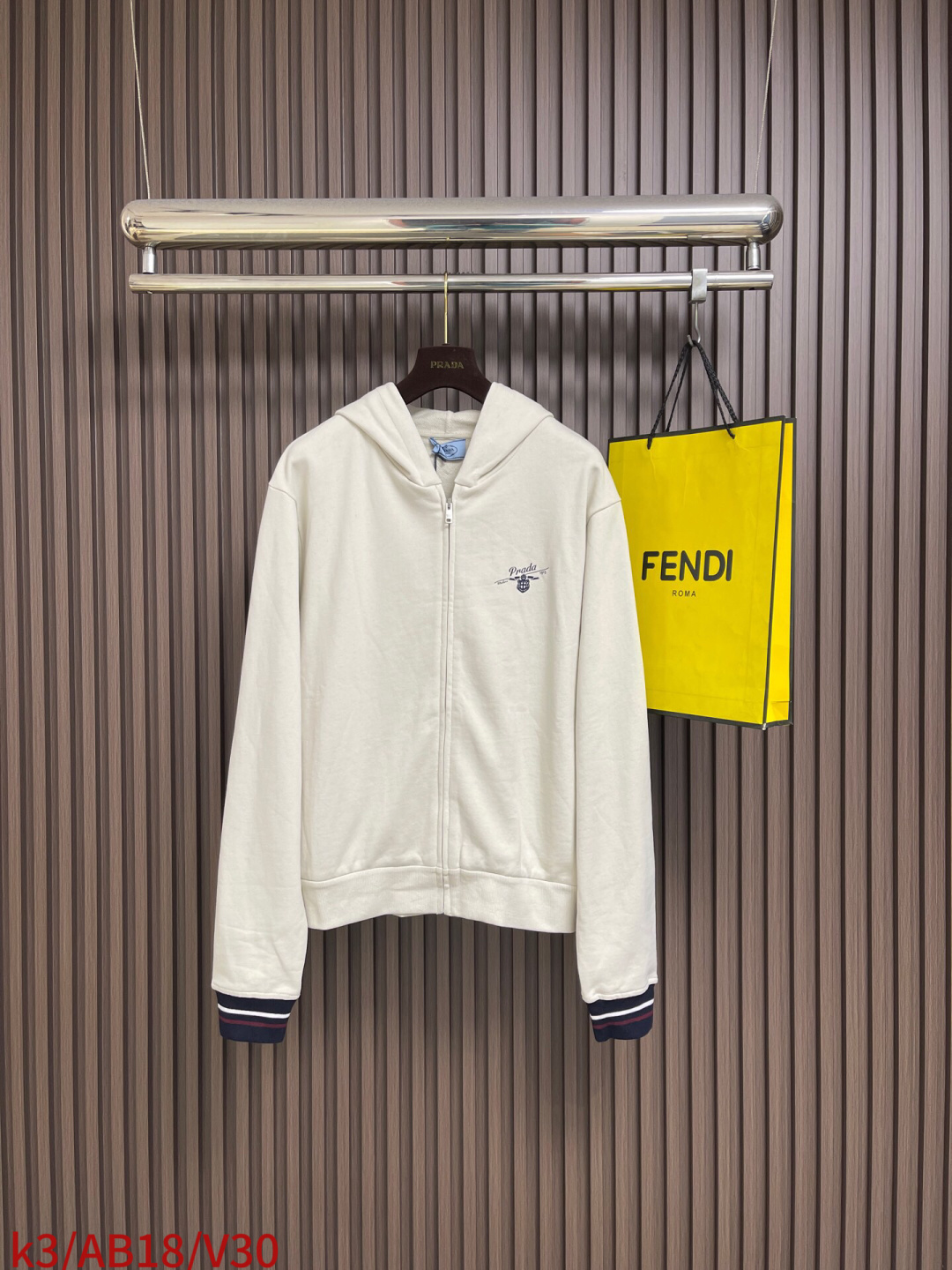 NO:756881,Prada  The college zipper hooded jacket uses a sweatshirt fabric structure of 32-count single yarn + 16-count yarn base, with a weight of 320gm2; it is matched with 21-count 1x1 ribs, with a weight of 380gm2. It is used on the collar, cuffs and hem, providing good elasticity and closing effect to ensure anti-  It is windy and neat. The heavy weight and balanced fabric in the body, 32-count single yarn provides a delicate and smooth outer surface; the 16-count yarn bottom is raised, forming a soft and warm fluff layer on the inside. The overall fabric is lighter and more flexible than traditional heavy sweaters, suitable for creating a combination of warmth and mobility  A jacket with easy movement. The Qianfu printing pattern adopts an environmentally friendly elastic glue printing process. The special environmentally friendly elastic glue is printed on the fabric through a screen and then solidified at high temperature. Its characteristics and functions are that the glue has good elasticity and can stretch with the fabric without cracking; it can present a matte or slightly glossy coating effect.  , a retro vision is achieved through old-fashioned color matching or craftsmanship; the touch is relatively soft, and there is no obvious hardened rubber feel, ensuring wearing comfort. This kind of printing is durable and full of color, suitable for expressing eye-catching iconic patterns. The overall wiring is straight and delicate, the fabric is comfortable and soft, and the color is consistent without color difference.  It can be matched with the same style to create a fashionable look, and can be used in various occasions. Customized accessories, complete with three standards, same style for men and women!  Sizes XS-L,,prada,hoodie,sweatshirts,jackets & coats,hats,19860909Prada 学院拉链连帽外套,采用32支单纱面＋16支纱底的卫衣面料结构,克重为320gm2；搭配的21支1x1罗纹,克重为380gm2.用于领口、袖口和下摆,提供了良好的弹性和收口定型效果,确保防风且利落.衣身中重磅且注重平衡感的面料,32支单纱提供了细腻、平滑的外表面；16支纱底经过起绒处理,在内侧形成柔软温暖的绒毛层.整体面料比传统重磅卫衣更显轻盈灵活,适合打造兼具保暖性与活动便利性的外套.前福印花图案采用环保弹力胶浆印花工艺,将特制的环保弹力浆料通过网版印刷在面料上,再经高温固化.其特点与作用在于浆料弹性好,可随面料拉伸不开裂；能呈现哑光或微光泽的涂层效果,通过做旧调色或工艺处理实现复古视觉；触感相对柔软,无明显硬化胶块感,保证了穿着的舒适度.这种印花耐用且色彩饱满,适合表达醒目的标志性图案.整体走线平直细腻,面料舒适柔软,颜色一致无色差 能与同款搭配营造时尚造型,驾驭各种场合,定制辅料,三标齐全,男女同款！尺码XS-L,,prada,hoodie,sweatshirts,jackets & coats,hats,,Men's clothing