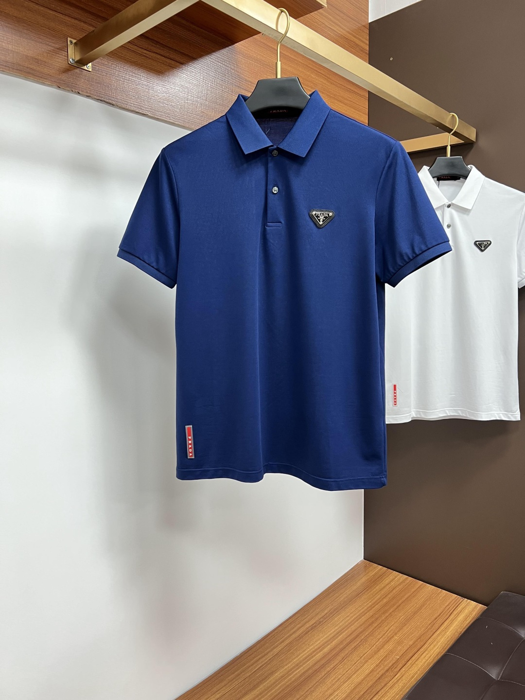 NO:162945,Prada Spring and Summer 2025 Classic Polo collar design, paired with simple single-breasted lines, neat and smooth lines, cleverly modifying the neck lines, showing elegant and gentlemanly style. The exquisite brand logo on the left chest adopts traceless pressing process, delicate and flat, low-key, and luxurious texture, showing the brand's ingenuity and quality pursuit in the subtleties. Selected high-quality fabrics, soft and smooth touch, good breathability, and comfortable and comfortable to wear. Whether it is to wear casual trousers to show professionalism and ability; or to combine it with jeans to create a daily look to create a relaxed and comfortable atmosphere, it can be perfectly adapted to help you interpret diverse styles with a calm attitude and show your unique taste. Size M-4XL,,prada,jeans,alexander wang19860909普拉达 2025春夏 经典的Polo领设计,搭配简洁的单排扣,线条利落流畅,巧妙修饰颈部线条,彰显优雅绅士格调.左胸处精致的品牌标识,采用无痕压胶工艺,细腻而平整,低调间流露奢华质感,于细微之处展现品牌匠心与品质追求. 精选优质面料,触感柔软顺滑,透气性佳,穿着舒适自在.无论是搭配休闲西裤出席商务场合,展现专业干练；还是与牛仔裤组合打造日常造型,营造轻松惬意氛围,它都能完美适配,助你以从容姿态诠释多样风格,尽显独特品味. 尺码M-4XL,,prada,jeans,alexander wang,Men's clothing