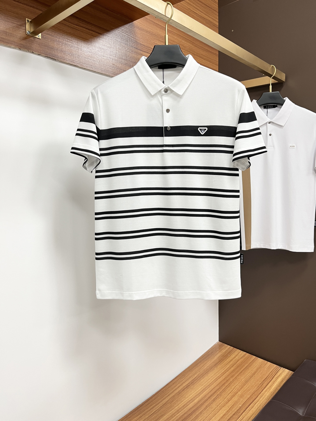 NO:426810,Prada 2025 spring and summer classic Polo collar design, paired with simple single-breasted lines, neat and smooth lines, cleverly modifying the neck lines, showing elegant and gentlemanly style. The exquisite brand logo on the left chest adopts traceless pressing process, delicate and flat, low-key, and luxurious texture, showing the brand's ingenuity and quality pursuit in the subtleties. Selected high-quality fabrics, soft and smooth, breathable, and comfortable and comfortable to wear. Whether it is to wear casual trousers to show professionalism and ability; or to combine with jeans to create a daily look to create a relaxed and comfortable atmosphere, it can be perfectly adapted. ZJ helps you interpret diverse styles with a calm attitude and show your unique taste. Size M-4XL,,prada,jeans,alexander wang19860909普拉达 2025春夏经典的Polo领设计,搭配简洁的单排扣,线条利落流畅,巧妙修饰颈部线条,彰显优雅绅士格调.左胸处精致的品牌标识,采用无痕压胶工艺,细腻而平整,低调间流露奢华质感,于细微之处展现品牌匠心与品质追求. 精选优质面料,触感柔软顺滑,透气性佳,穿着舒适自在.无论是搭配休闲西裤出席商务场合,展现专业干练；还是与牛仔裤组合打造日常造型,营造轻松惬意氛围,它都能完美适配,ZJ助你以从容姿态诠释多样风格,尽显独特品味. 尺码M-4XL,,prada,jeans,alexander wang,Men's clothing