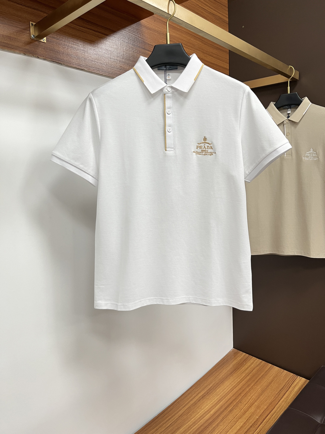 NO:455093,Prada 2025 spring and summer classic Polo collar design, paired with simple single-breasted lines, neat and smooth lines, cleverly modifying the neck lines, showing elegant and gentlemanly style. The exquisite brand logo on the left chest adopts traceless pressing process, delicate and flat, low-key, and luxurious texture, showing the brand's ingenuity and quality pursuit in the subtleties. Selected high-quality fabrics, soft and smooth, breathable, and comfortable and comfortable to wear. Whether it is to wear casual trousers to show professionalism and ability; or to combine them with jeans to create a daily look to create a relaxed and comfortable atmosphere, it can be perfectly adapted. AM helps you interpret diverse styles with a calm attitude and show your unique taste. Size M-3XL,,prada,jeans,alexander wang19860909普拉达 2025春夏经典的Polo领设计,搭配简洁的单排扣,线条利落流畅,巧妙修饰颈部线条,彰显优雅绅士格调.左胸处精致的品牌标识,采用无痕压胶工艺,细腻而平整,低调间流露奢华质感,于细微之处展现品牌匠心与品质追求. 精选优质面料,触感柔软顺滑,透气性佳,穿着舒适自在.无论是搭配休闲西裤出席商务场合,展现专业干练；还是与牛仔裤组合打造日常造型,营造轻松惬意氛围,它都能完美适配,AM助你以从容姿态诠释多样风格,尽显独特品味. 尺码M-3XL,,prada,jeans,alexander wang,Men's clothing