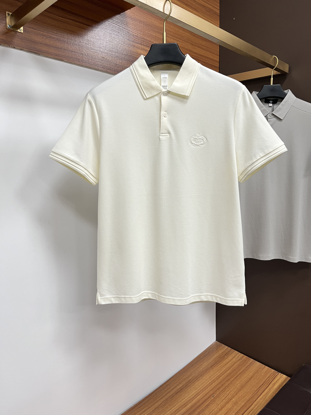 NO:512131,Prada 2025 spring and summer classic Polo collar design, paired with simple single-breasted lines, neat and smooth lines, cleverly modifying the neck lines, showing elegant and gentlemanly style. The exquisite brand logo on the left chest adopts traceless pressing process, delicate and flat, low-key, and luxurious texture, showing the brand's ingenuity and quality pursuit in the subtleties. Selected high-quality fabrics, soft and smooth, breathable, and comfortable and comfortable to wear. Whether it is to wear casual trousers to show professionalism and ability; or to combine them with jeans to create a daily look to create a relaxed and comfortable atmosphere, it can be perfectly adapted. AM helps you interpret diverse styles with a calm attitude and show your unique taste. Size M-3XL,,prada,jeans,alexander wang19860909普拉达 2025春夏经典的Polo领设计,搭配简洁的单排扣,线条利落流畅,巧妙修饰颈部线条,彰显优雅绅士格调.左胸处精致的品牌标识,采用无痕压胶工艺,细腻而平整,低调间流露奢华质感,于细微之处展现品牌匠心与品质追求. 精选优质面料,触感柔软顺滑,透气性佳,穿着舒适自在.无论是搭配休闲西裤出席商务场合,展现专业干练；还是与牛仔裤组合打造日常造型,营造轻松惬意氛围,它都能完美适配,AM助你以从容姿态诠释多样风格,尽显独特品味. 尺码M-3XL,,prada,jeans,alexander wang,Men's clothing