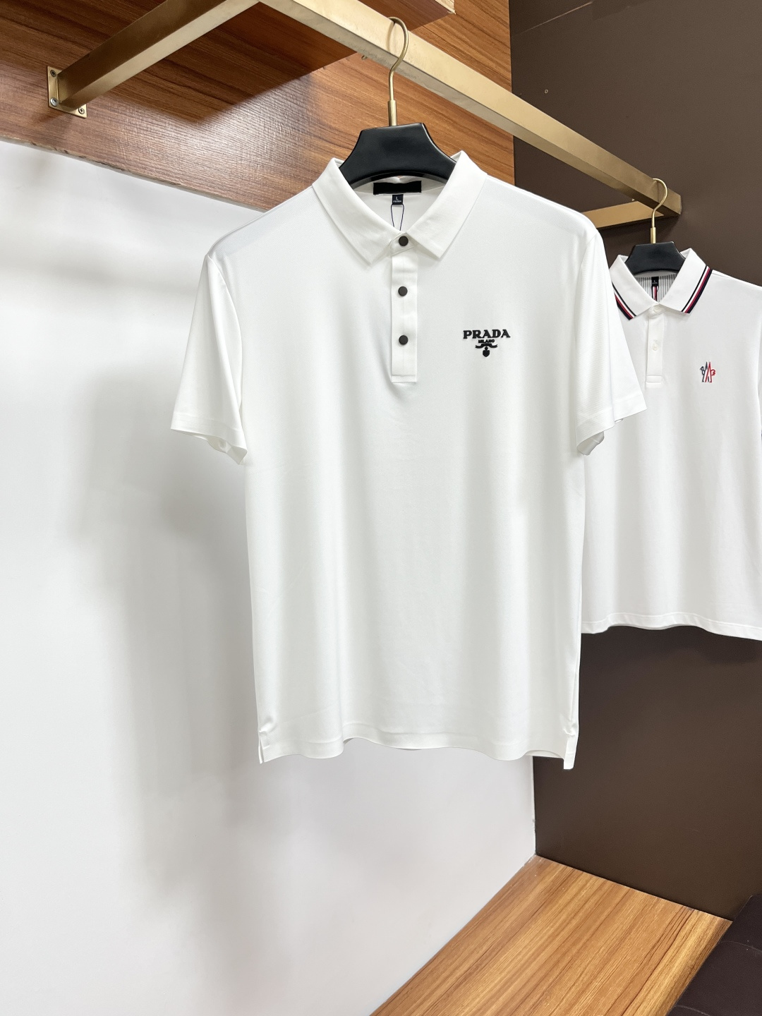 NO:849435,Prada  The classic Polo collar design for spring and summer 2026, with simple single-breasted buttons, neat and smooth lines, cleverly modifying the neck line, showing an elegant gentleman's style. The exquisite brand logo on the left chest uses a seamless gluing process, which is delicate and smooth, revealing a luxurious texture in a low-key manner, showing the brand's ingenuity and pursuit of quality in every detail. Selected high-quality fabrics, soft to the touch  It is soft and smooth, has good breathability, and is comfortable to wear. Whether it is paired with casual trousers to attend business occasions to show professionalism or combined with jeans to create a daily look to create a relaxed and comfortable atmosphere, it can be perfectly adapted. BG helps you interpret various styles with ease and show your unique taste. Sizes M-4XL, prada, jeans,19860909普拉达 2026春夏经典的Polo领设计,搭配简洁的单排扣,线条利落流畅,巧妙修饰颈部线条,彰显优雅绅士格调.左胸处精致的品牌标识,采用无痕压胶工艺,细腻而平整,低调间流露奢华质感,于细微之处展现品牌匠心与品质追求.精选优质面料,触感柔软顺滑,透气性佳,穿着舒适自在.无论是搭配休闲西裤出席商务场合,展现专业干练；还是与牛仔裤组合打造日常造型,营造轻松惬意氛围,它都能完美适配,BG助你以从容姿态诠释多样风格,尽显独特品味.尺码M-4XL,,prada,jeans,,Men's clothing