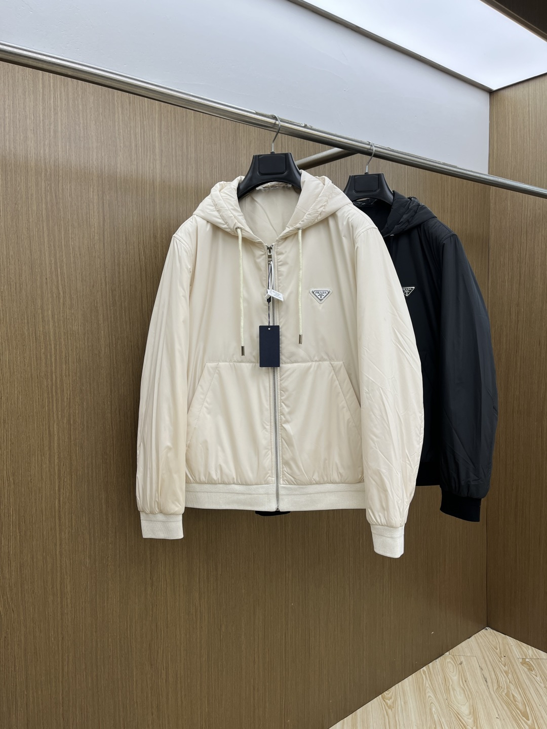 秋冬 PRA25FW秋冬新款黑色尼龙抽绳连帽棉衣外套 男女同款金属三角标徽章装饰轻薄款连帽棉服夹克外套！