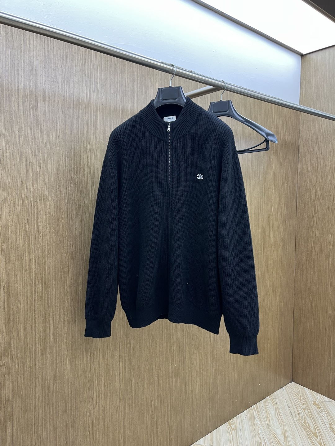 NO:654010,CELINE black knitting, French simplicity hidden in a zipper cardigan. Black-tone pitted knitting, CELINE logo is low-key and refined. French relaxation, a CELINE zipper cardigan is enough.  The classic black tone collides with the pitted knitted texture. This zippered cardigan from CELINE implements French minimalism to the end. The half-high collar zipper design takes into account the convenience of putting on and taking off and the modification of the neck line. The brand logo on the chest is small and eye-catching. There is no complicated decoration, and only the texture and pattern support the sense of luxury. The relaxed silhouette is suitable for various daily scenes. Whether worn alone or layered, Gz can easily wear an effortless French style. Color black  Size S-XXL,,celine,celine,alexander wang19860909CELINE赛琳黑针织,拉链开衫藏住的法式简约 黑调坑条针织,CELINE徽标是低调的精致 法式松弛感,一件CELINE拉链开衫就够了 经典黑调碰撞坑条针织肌理,CELINE这款拉链开衫将法式极简贯彻到底.半高领的拉链设计兼顾穿脱便利与颈部线条修饰,胸口的品牌徽标小巧点睛,没有繁复装饰,仅以质感和版型撑起高级感.松弛的廓形适配各种日常场景,无论是单穿还是叠搭,Gz都能轻松穿出毫不费力的法式格调. 颜色黑色 尺码S-XXL,,celine,celine,alexander wang,Men's clothing