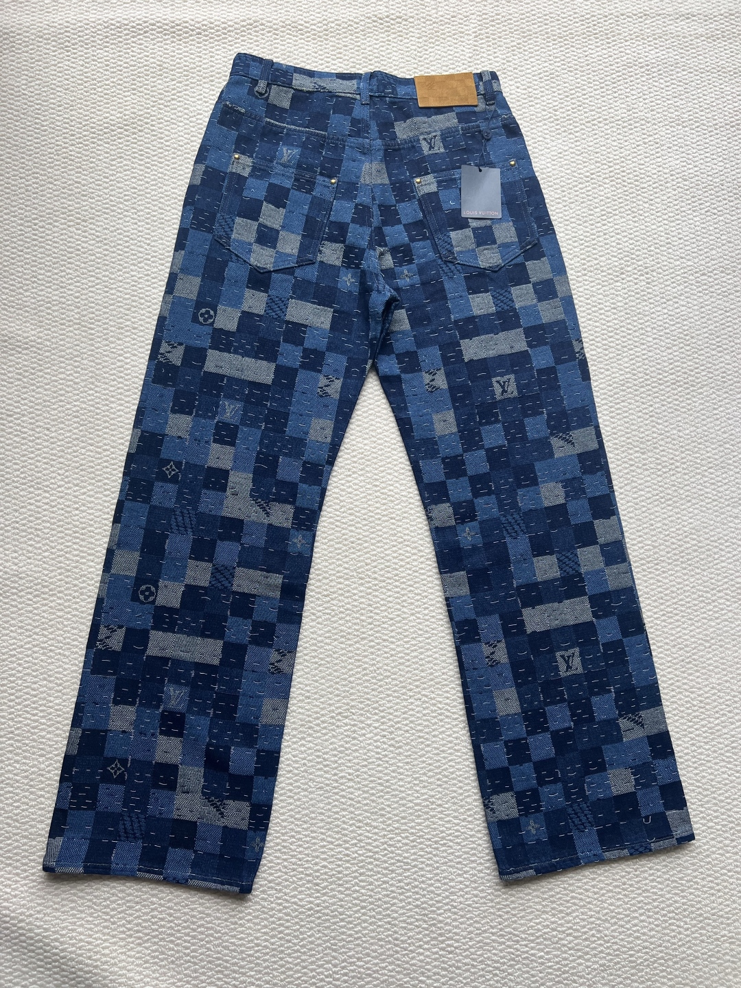 P240 LOUIS VUITTON✖️Nigo联名提花棋盘格牛仔长裤
工艺说明:这款滑板来自Pharrell Williams与Nigo合作的2025秋冬系列,采用100%纯棉面料打造,兼具舒适度与耐用性。设计上巧妙融合了品牌标志性的Damier格纹元素,通过独特的拼缝工艺向日本传统拼布技艺致敬。裤身采用经典五袋剪裁,搭配珠光纽扣前襟和铆钉装饰,细节处尽显精致。全幅标识提花工艺彰显品牌辨识度,正绒面革标签则增添了高级质感。整体版型专为滑板运动设计,既保持活动自由度又不失时尚感。可与同系列搭配,完整呈现秀场造型。珠光元素的运用与格纹图案相得益彰,展现出品牌对传统工艺与现代潮流的完美平衡。
码数:30-32-34-36