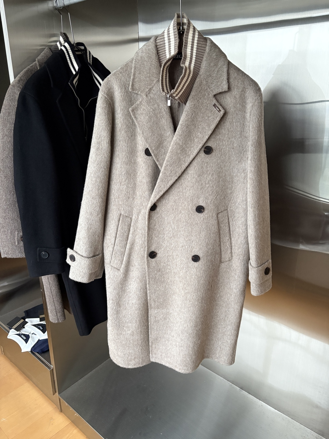 NO:683746,Jeni 25FW new autumn and winter wool coat, wool coat interprets the elegance and warmth of winter] The winter wind brings biting and chill, but it also brings fashion opportunities. When the classic herringbone pattern meets wool fabric, a unique coat emerges, adding an irresistible charm to your winter outfit.  With the herringbone texture as the design highlight, the unique pattern seems to tell the story of the years, adding a retro and literary atmosphere to the overall look. Its style is simple yet grand, and the smooth lines outline an elegant outline. Whether it is worn open to show casualness, or buttoned up to create a neat look, it can easily control various styles.  What’s even more surprising is that this coat can be worn with a stand-up collar. The stand-up collar design can not only provide warm protection for your neck in the cold wind, but also instantly enhance your aura and make you stand out from the crowd. When the cold wind blows, stand the collar high, as if you are building a warm barrier for yourself, while still maintaining a sense of fashion.  The choice of fabric is the essence of this coat. The blend of wool and cashmere combines the stiffness of wool with the softness of cashmere. Wool gives the coat good support and warmth, making it able to withstand the severe cold of winter; while the addition of cashmere makes the coat more delicate and skin-friendly to the touch, as if it is wrapped in a layer of soft clouds. This blended fabric is not only comfortable to wear, but also has a high-quality texture, showing a high-quality style.  In terms of color, we have carefully blended two classic tones, dark gray and light coffee. Dark gray is calm and restrained, suitable for you who pursue low-key luxury; light coffee is warm and soft, adding a warm color to winter. No matter what style lover you are, you can find your favorite choice in these two colors. Size M-3XL,,zegna,19860909杰尼25FW秋冬新款羊毛大衣,羊毛大衣演绎冬日的优雅与温暖】冬日的风,带着凛冽与寒意,却也吹来了时尚的契机.当经典的人字纹邂逅羊毛面料,一件别具一格的大衣应运而生,为你的冬日穿搭增添一抹难以抗拒的魅力. 以人字纹理为设计亮点,独特的纹路仿佛在诉说着岁月的故事,为整体造型增添了复古与文艺的气息.它的款式外形简约而不失大气,流畅的线条勾勒出优雅的轮廓,无论是敞开穿展现随性,还是系上扣子塑造利落感,都能轻松驾驭各种风格. 更令人惊喜的是,这款大衣可以实现立领的穿搭方式.立领的设计不仅能在寒风中为你的脖颈提供温暖的守护,还能瞬间提升气场,让你在人群中脱颖而出.当寒风乍起,将领子高高立起,仿佛为自己筑起一道温暖的屏障,同时又不失时尚感. 而面料的选择,更是这款大衣的精髓所在.羊毛与山羊绒的混纺,兼具了羊毛的挺括与山羊绒的柔软.羊毛赋予了大衣良好的支撑性和保暖性,使其能够抵御冬日的严寒；而山羊绒的加入,则让大衣在触感上更加细腻亲肤,仿佛被一层轻柔的云朵包裹.这种混纺面料不仅穿着舒适,而且质感上乘,彰显出高品质的格调. 在色彩上,我们精心调配了深灰与浅咖两种经典色调.深灰,沉稳内敛,适合追求低调奢华的你；浅咖,温暖柔和,为冬日增添一抹温馨的色彩.无论你是哪种风格爱好者,都能在这两款颜色中找到属于自己的心仪之选. 码数M-3XL,,zegna,,Men's clothing