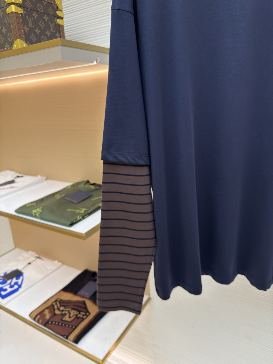 P145 MIUMIU棕条纹假两件长袖
●原版：8269购入开发
●货号：1680700-A20
●面料：棉质平纹针织面料
●工艺：针织提花制作
●版型：宽松版型
●克重：约350克
●尺码：XS-S-M-L
●描述：采用24S特纺紧密棉面料，185g；搭配32S双纱螺纹，300g。紧密纺强力比传统单纱高，紧密纱中的单纤维排列紧密，有助于提高纱线的强力。纤维的端头均捻入纱线内，因此成纱非常紧密，纱线外观光洁毛羽少。紧密纺纱线强力较高毛羽较少，不易产生磨毛的现象。采用24S提花条纹工艺特种纺织紧密棉 ，200g；搭配提花工艺复杂织造技术，通过经纬纱线的交错形成条纹图案，赋予面料立体感和层次感，视觉上更显高级。条纹通过提花工艺呈现，比普通印花或染色条纹更持久不易褪色，且纹理清晰、边界分明，经典复古与现代摩登结合的风格。通常选用混纺纱线，徽标面料柔软亲肤且不易变形。纱线支数较高织物质地细腻紧密，精细提花图案徽标增强视觉层次感。整体走线平直细腻，面料舒适柔软，颜色一致无色差 能与同款搭配营造时尚造型，驾驭各种场合，定制辅料，三标齐全，男女同款！