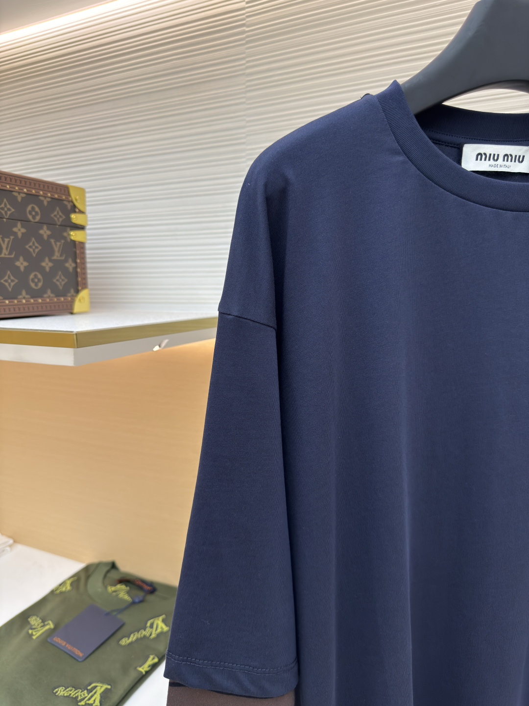 P145 MIUMIU棕条纹假两件长袖
●原版：8269购入开发
●货号：1680700-A20
●面料：棉质平纹针织面料
●工艺：针织提花制作
●版型：宽松版型
●克重：约350克
●尺码：XS-S-M-L
●描述：采用24S特纺紧密棉面料，185g；搭配32S双纱螺纹，300g。紧密纺强力比传统单纱高，紧密纱中的单纤维排列紧密，有助于提高纱线的强力。纤维的端头均捻入纱线内，因此成纱非常紧密，纱线外观光洁毛羽少。紧密纺纱线强力较高毛羽较少，不易产生磨毛的现象。采用24S提花条纹工艺特种纺织紧密棉 ，200g；搭配提花工艺复杂织造技术，通过经纬纱线的交错形成条纹图案，赋予面料立体感和层次感，视觉上更显高级。条纹通过提花工艺呈现，比普通印花或染色条纹更持久不易褪色，且纹理清晰、边界分明，经典复古与现代摩登结合的风格。通常选用混纺纱线，徽标面料柔软亲肤且不易变形。纱线支数较高织物质地细腻紧密，精细提花图案徽标增强视觉层次感。整体走线平直细腻，面料舒适柔软，颜色一致无色差 能与同款搭配营造时尚造型，驾驭各种场合，定制辅料，三标齐全，男女同款！