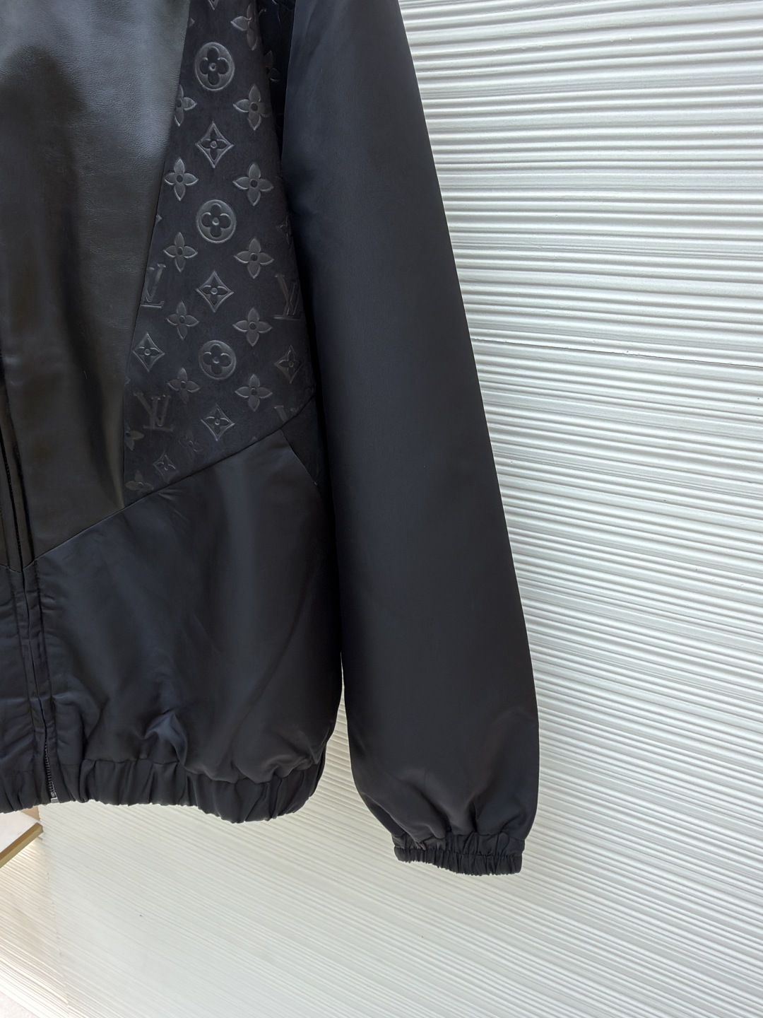 P345 LOUIS VUITTON 老花压纹拼接皮衣夹克
●原版：32999购入开发
●货号：1680916-C10
●面料：锦纶面料
●工艺：压纹制作
●版型：合身版型
●克重：约815克
●尺码：S-M-L-XL
●描述：衣身主体采用的是100%锦纶材质，透气性超棒，穿上身一点都不会觉得闷热，袖口、领部还有前襟这些地方，都融入了柔软的羊皮革，摸起来那叫一个顺滑，质感直接拉满!经典的Monogram压纹绒面皮革嵌饰，高领设计搭配弹力袖口和下摆，不仅防风保暖，还能让你活动自如，完全不会有束缚感!侧边的拉链开合设计也很贴心，穿脱特别方便，两侧还有实用的口袋，能放不少小物件，功能性直接拉满，能与多类型服饰搭配营造时尚造型。整体走线平直细腻，面料舒适柔软，颜色一致无色差 能与同款搭配营造时尚造型，驾驭各种场合，定制辅料，三标齐全，男女同款！