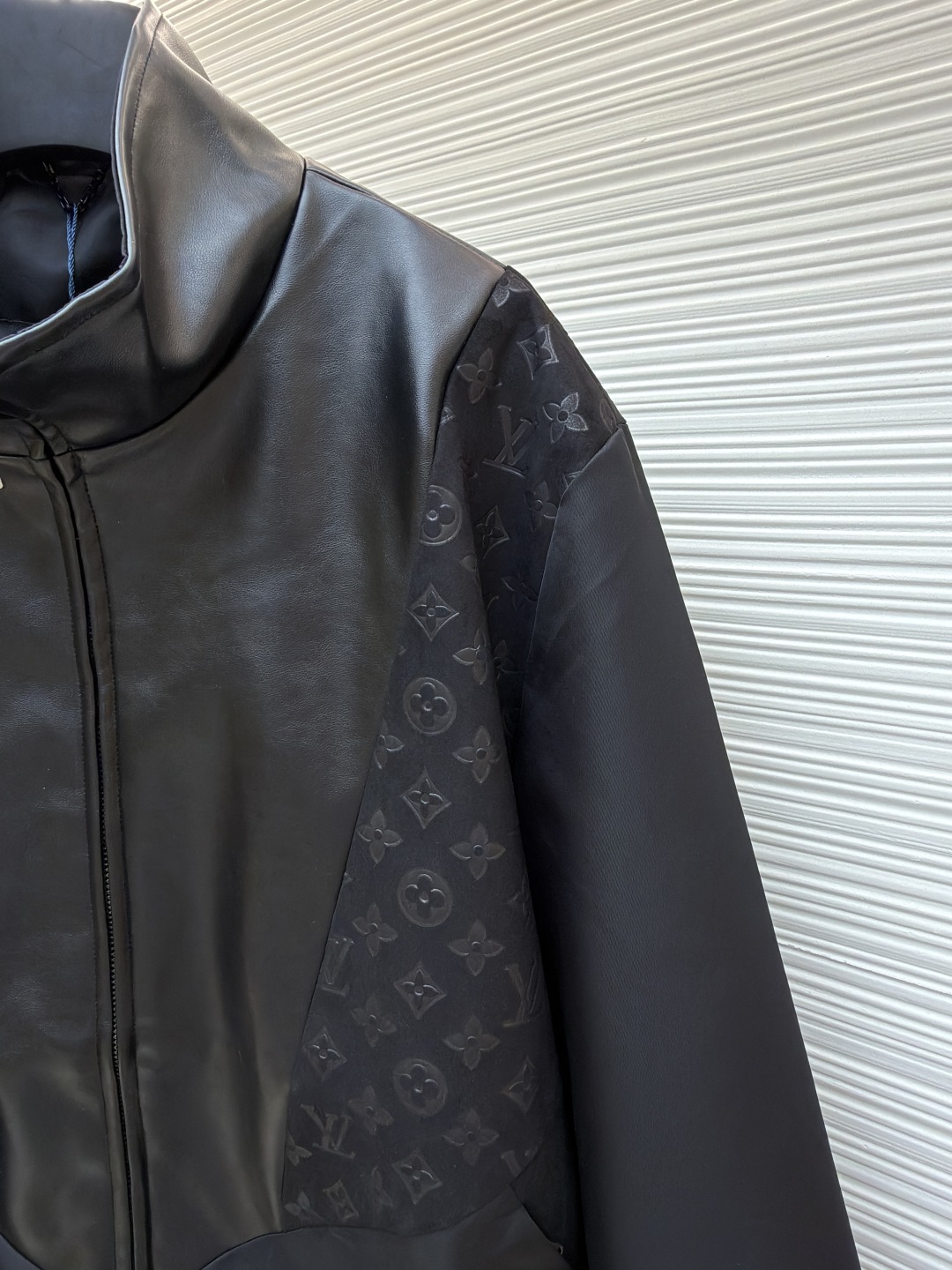 P345 LOUIS VUITTON 老花压纹拼接皮衣夹克
●原版：32999购入开发
●货号：1680916-C10
●面料：锦纶面料
●工艺：压纹制作
●版型：合身版型
●克重：约815克
●尺码：S-M-L-XL
●描述：衣身主体采用的是100%锦纶材质，透气性超棒，穿上身一点都不会觉得闷热，袖口、领部还有前襟这些地方，都融入了柔软的羊皮革，摸起来那叫一个顺滑，质感直接拉满!经典的Monogram压纹绒面皮革嵌饰，高领设计搭配弹力袖口和下摆，不仅防风保暖，还能让你活动自如，完全不会有束缚感!侧边的拉链开合设计也很贴心，穿脱特别方便，两侧还有实用的口袋，能放不少小物件，功能性直接拉满，能与多类型服饰搭配营造时尚造型。整体走线平直细腻，面料舒适柔软，颜色一致无色差 能与同款搭配营造时尚造型，驾驭各种场合，定制辅料，三标齐全，男女同款！