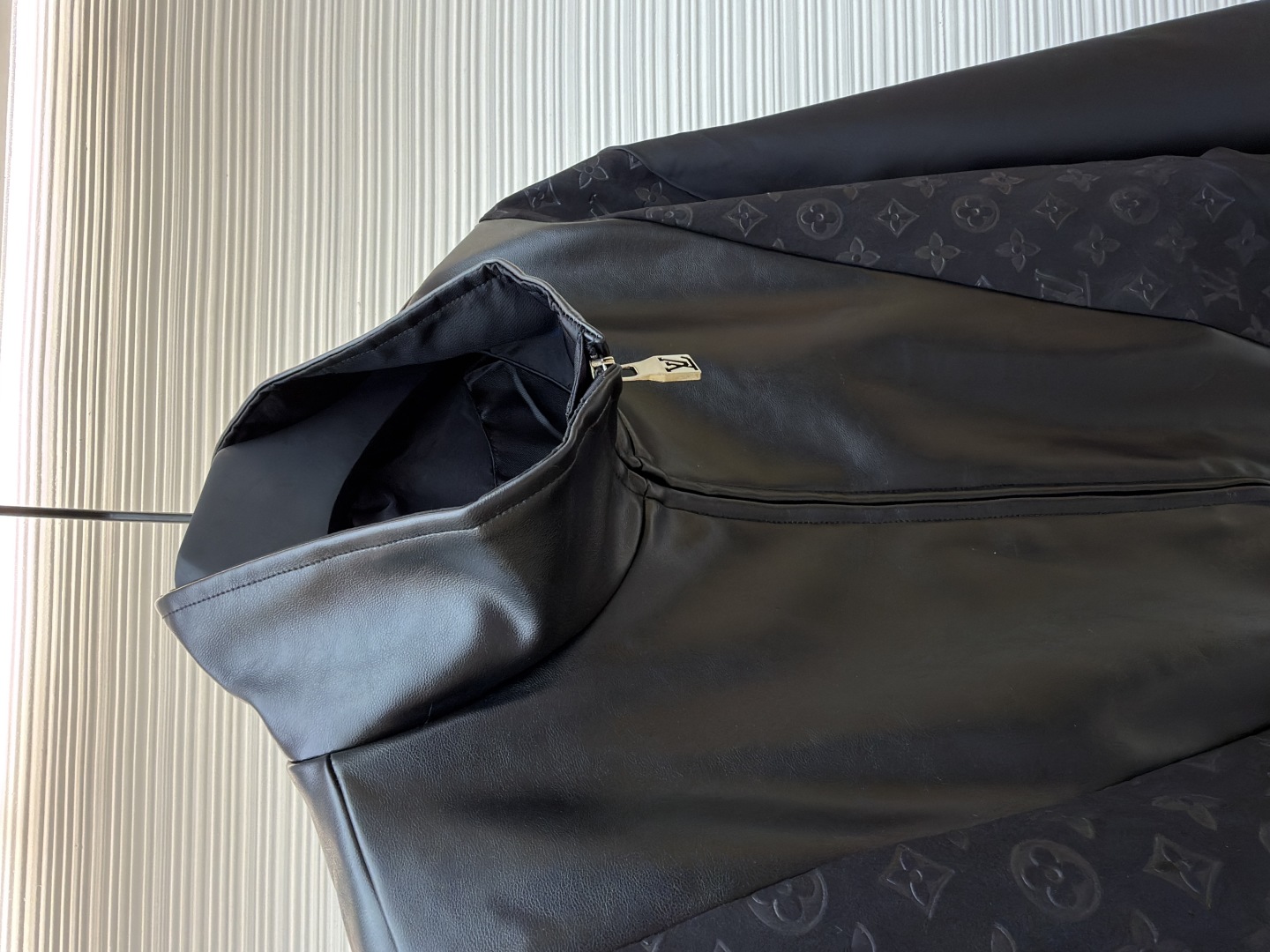 P345 LOUIS VUITTON 老花压纹拼接皮衣夹克
●原版：32999购入开发
●货号：1680916-C10
●面料：锦纶面料
●工艺：压纹制作
●版型：合身版型
●克重：约815克
●尺码：S-M-L-XL
●描述：衣身主体采用的是100%锦纶材质，透气性超棒，穿上身一点都不会觉得闷热，袖口、领部还有前襟这些地方，都融入了柔软的羊皮革，摸起来那叫一个顺滑，质感直接拉满!经典的Monogram压纹绒面皮革嵌饰，高领设计搭配弹力袖口和下摆，不仅防风保暖，还能让你活动自如，完全不会有束缚感!侧边的拉链开合设计也很贴心，穿脱特别方便，两侧还有实用的口袋，能放不少小物件，功能性直接拉满，能与多类型服饰搭配营造时尚造型。整体走线平直细腻，面料舒适柔软，颜色一致无色差 能与同款搭配营造时尚造型，驾驭各种场合，定制辅料，三标齐全，男女同款！