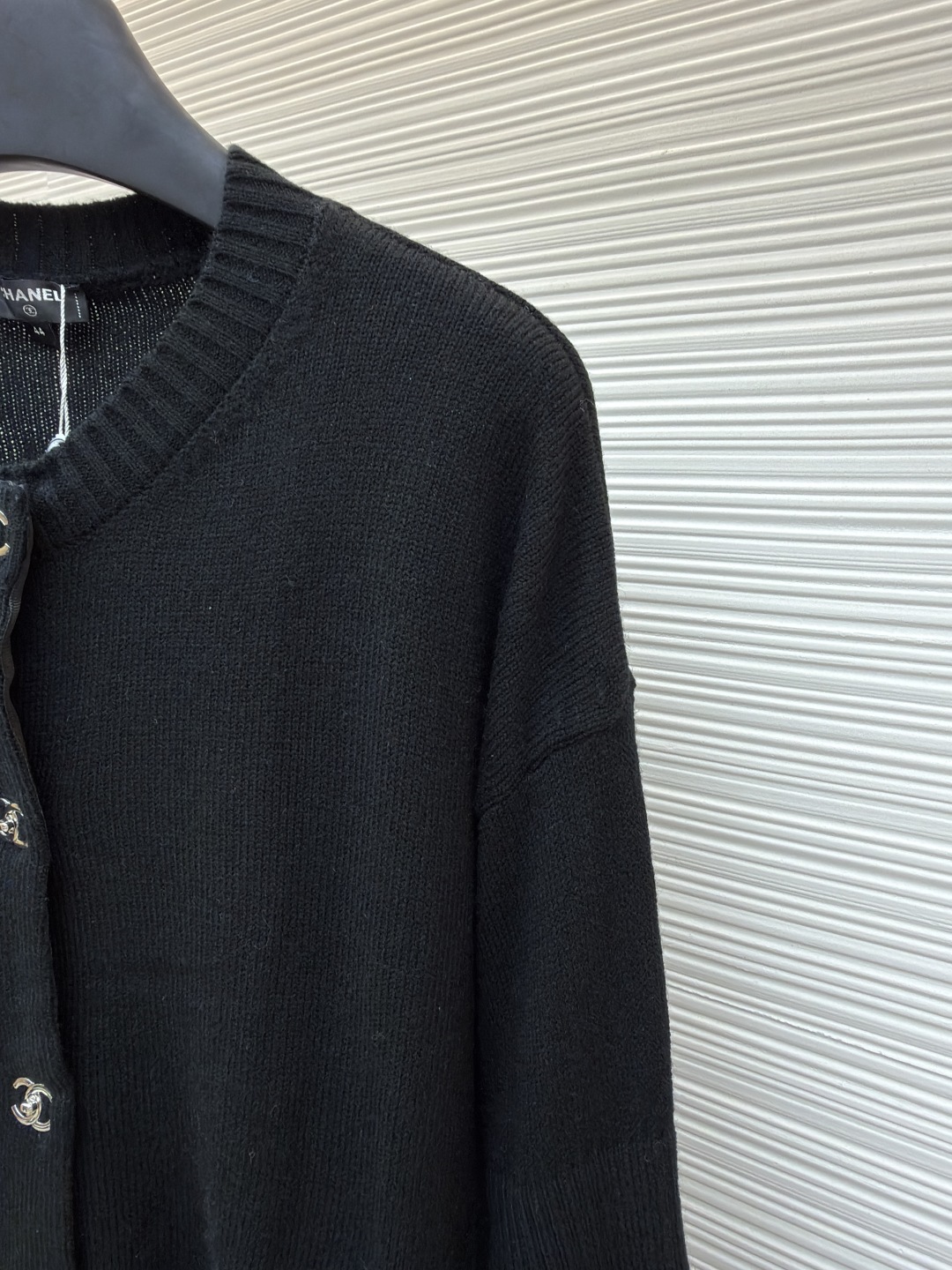 P275 Chanel 书包扣针织开衫
●原版：42600购入开发
●货号：1680973-B40
●面料：羊绒锦缎混纺面料
●工艺：人工专机起针打钉制作
●版型：合身版型
●克重：约495克
●尺码：40-42-44-46
●描述：定制羊绒锦缎混纺料 光泽自然 柔软亲肤 熠熠生辉的标志性双C扣装饰全幅 彰显品牌尊贵身份 流畅的剪裁线条 勾勒出穿着者的曼妙身姿 完美诠释现代时尚精髓 穿搭中的时尚瑰宝。采用接缝立体缝线 它通过在接缝处使用特定的缝纫方法 使衣物呈现出更加立体和贴合身体的效果 做工繁琐复杂。人工专机起针打钉 在钉扣起始点 精确起针 采用高质量的针线和专用缝纫机 沿预设路径 匀速缝纫 保持力度均匀 确保缝线美观，成衣洗水加软去味工艺 通过专业的洗涤设备和特定的洗涤剂 对衣物进行深度清洁和去味处理 改善衣物的手感和外观。整体走线平直细腻，面料舒适柔软，颜色一致无色差 能与同款搭配营造时尚造型，驾驭各种场合，定制辅料，三标齐全，男女同款！