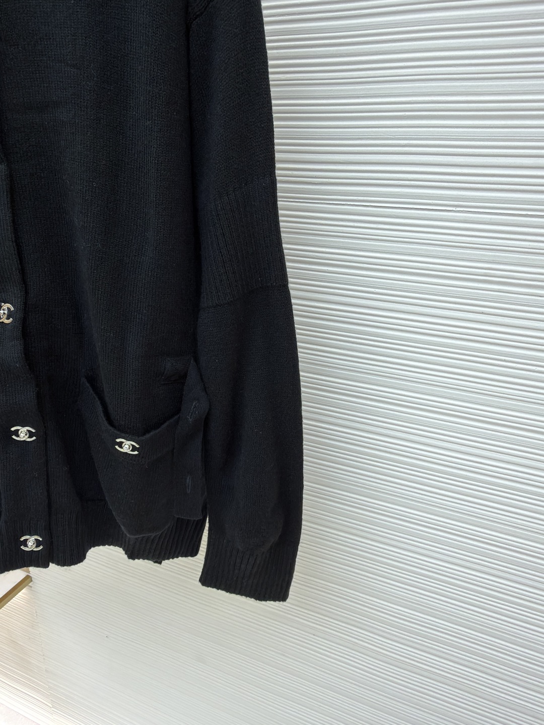 P275 Chanel 书包扣针织开衫
●原版：42600购入开发
●货号：1680973-B40
●面料：羊绒锦缎混纺面料
●工艺：人工专机起针打钉制作
●版型：合身版型
●克重：约495克
●尺码：40-42-44-46
●描述：定制羊绒锦缎混纺料 光泽自然 柔软亲肤 熠熠生辉的标志性双C扣装饰全幅 彰显品牌尊贵身份 流畅的剪裁线条 勾勒出穿着者的曼妙身姿 完美诠释现代时尚精髓 穿搭中的时尚瑰宝。采用接缝立体缝线 它通过在接缝处使用特定的缝纫方法 使衣物呈现出更加立体和贴合身体的效果 做工繁琐复杂。人工专机起针打钉 在钉扣起始点 精确起针 采用高质量的针线和专用缝纫机 沿预设路径 匀速缝纫 保持力度均匀 确保缝线美观，成衣洗水加软去味工艺 通过专业的洗涤设备和特定的洗涤剂 对衣物进行深度清洁和去味处理 改善衣物的手感和外观。整体走线平直细腻，面料舒适柔软，颜色一致无色差 能与同款搭配营造时尚造型，驾驭各种场合，定制辅料，三标齐全，男女同款！