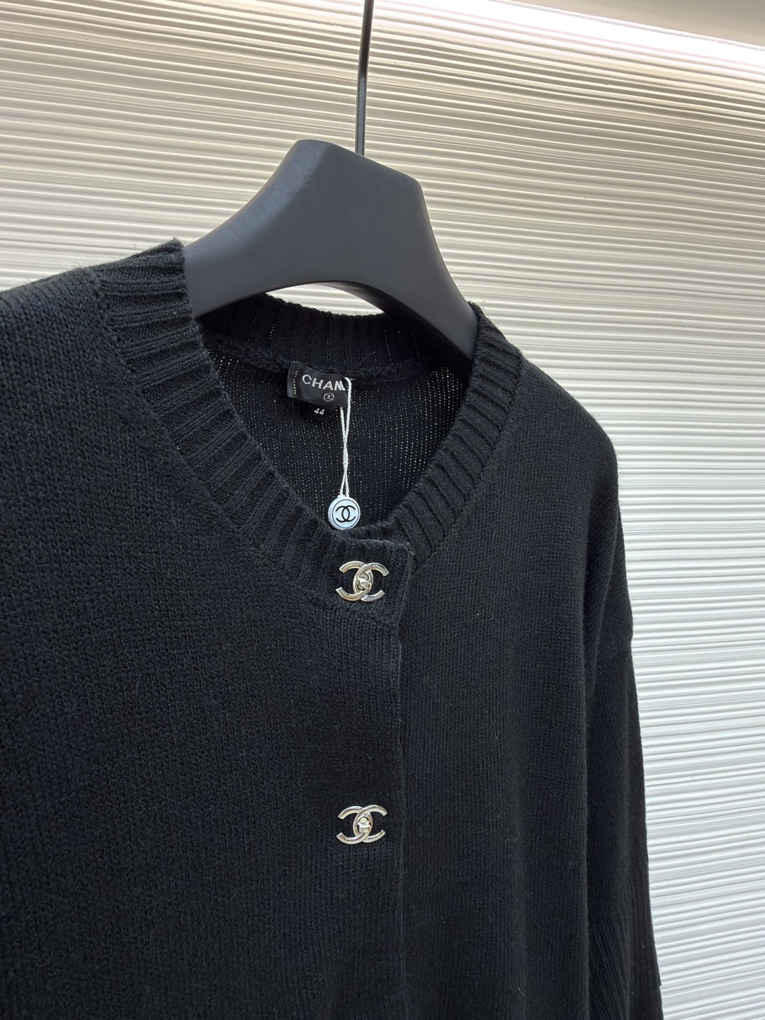 P275 Chanel 书包扣针织开衫
●原版：42600购入开发
●货号：1680973-B40
●面料：羊绒锦缎混纺面料
●工艺：人工专机起针打钉制作
●版型：合身版型
●克重：约495克
●尺码：40-42-44-46
●描述：定制羊绒锦缎混纺料 光泽自然 柔软亲肤 熠熠生辉的标志性双C扣装饰全幅 彰显品牌尊贵身份 流畅的剪裁线条 勾勒出穿着者的曼妙身姿 完美诠释现代时尚精髓 穿搭中的时尚瑰宝。采用接缝立体缝线 它通过在接缝处使用特定的缝纫方法 使衣物呈现出更加立体和贴合身体的效果 做工繁琐复杂。人工专机起针打钉 在钉扣起始点 精确起针 采用高质量的针线和专用缝纫机 沿预设路径 匀速缝纫 保持力度均匀 确保缝线美观，成衣洗水加软去味工艺 通过专业的洗涤设备和特定的洗涤剂 对衣物进行深度清洁和去味处理 改善衣物的手感和外观。整体走线平直细腻，面料舒适柔软，颜色一致无色差 能与同款搭配营造时尚造型，驾驭各种场合，定制辅料，三标齐全，男女同款！