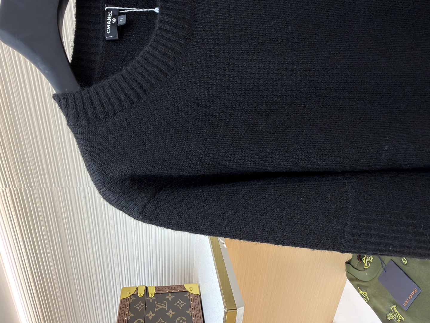 P230 Chanel 书包扣长袖毛衣
●货号：1680976-B00
●面料：百花绒镶羊毛面料
●工艺：成衣洗水制作
●版型：合身版型
●克重：约440克
●尺码：38-40-42-44-46
●描述定织百花绒镶羊毛织料 光泽自然 柔软亲肤 以深邃黑色为底色 不喧哗却自带光芒 肩部巧妙融入标志性香奈儿书包扣设计 宛如灵动的音符 为简约轮廓注入奢华灵魂 以慵懒而不失优雅的姿态 贴合身体线条 在黑色的渲染下更显沉稳内敛 自成一道优雅风景，采用接缝立体缝线 它通过在接缝处使用特定的缝纫方法 使衣物呈现出更加立体和贴合身体的效果 做工繁琐复杂，人工专机起针打钉 在钉扣起始点 精确起针 采用高质量的针线和专用缝纫机 沿预设路径 匀速缝纫 保持力度均匀 确保缝线美观，成衣洗水加软去味工艺 通过专业的洗涤设备和特定的洗涤剂 对衣物进行深度清洁和去味处理 改善衣物的手感和外观。整体走线平直细腻，面料舒适柔软，颜色一致无色差 能与同款搭配营造时尚造型，驾驭各种场合，定制辅料，三标齐全，男女同款！