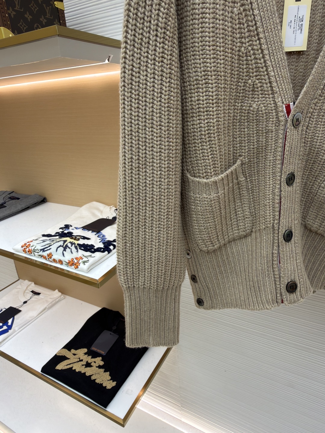 P365 THOM BROWNE四杠加厚元宝针开衫
●货号:1681466-C30
●面料:混纺面料
●工艺:针织制作
●颜色:驼色
●版型:宽松版型
●克重:约570克
●尺码:1-2-3-4
●描述:该开衫采用粗针针织工艺,选用质感细腻的纱线编织,衣身纹理粗犷且富有层次,营造出复古休闲的风格。细节工艺上,左臂的四条纹撞色针织工艺是品牌标志性设计,条纹与主色的搭配精准且富有辨识度;门襟与下摆的金属纽扣工艺,纽扣质感厚重,做工精细,既具实用性又提升了整体精致度;双贴袋的立体针织工艺,袋型挺括,与衣身针织纹理浑然一体。从粗针编织的整体质感,到条纹、纽扣、口袋的细节处理,每一处工艺都体现出品牌对经典风格与精湛工艺的坚持,打造出兼具辨识度与品质感的针织单品。整体走线平直细腻,面料舒适柔软,颜色一致无色差 能与同款搭配营造时尚造型,驾驭各种场合,定制辅料,三标齐全,男女同款!