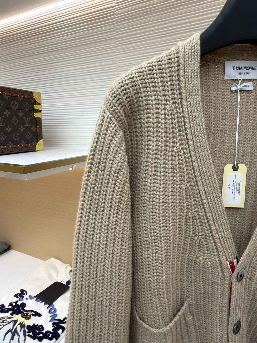 P365 THOM BROWNE四杠加厚元宝针开衫
●货号:1681466-C30
●面料:混纺面料
●工艺:针织制作
●颜色:驼色
●版型:宽松版型
●克重:约570克
●尺码:1-2-3-4
●描述:该开衫采用粗针针织工艺,选用质感细腻的纱线编织,衣身纹理粗犷且富有层次,营造出复古休闲的风格。细节工艺上,左臂的四条纹撞色针织工艺是品牌标志性设计,条纹与主色的搭配精准且富有辨识度;门襟与下摆的金属纽扣工艺,纽扣质感厚重,做工精细,既具实用性又提升了整体精致度;双贴袋的立体针织工艺,袋型挺括,与衣身针织纹理浑然一体。从粗针编织的整体质感,到条纹、纽扣、口袋的细节处理,每一处工艺都体现出品牌对经典风格与精湛工艺的坚持,打造出兼具辨识度与品质感的针织单品。整体走线平直细腻,面料舒适柔软,颜色一致无色差 能与同款搭配营造时尚造型,驾驭各种场合,定制辅料,三标齐全,男女同款!