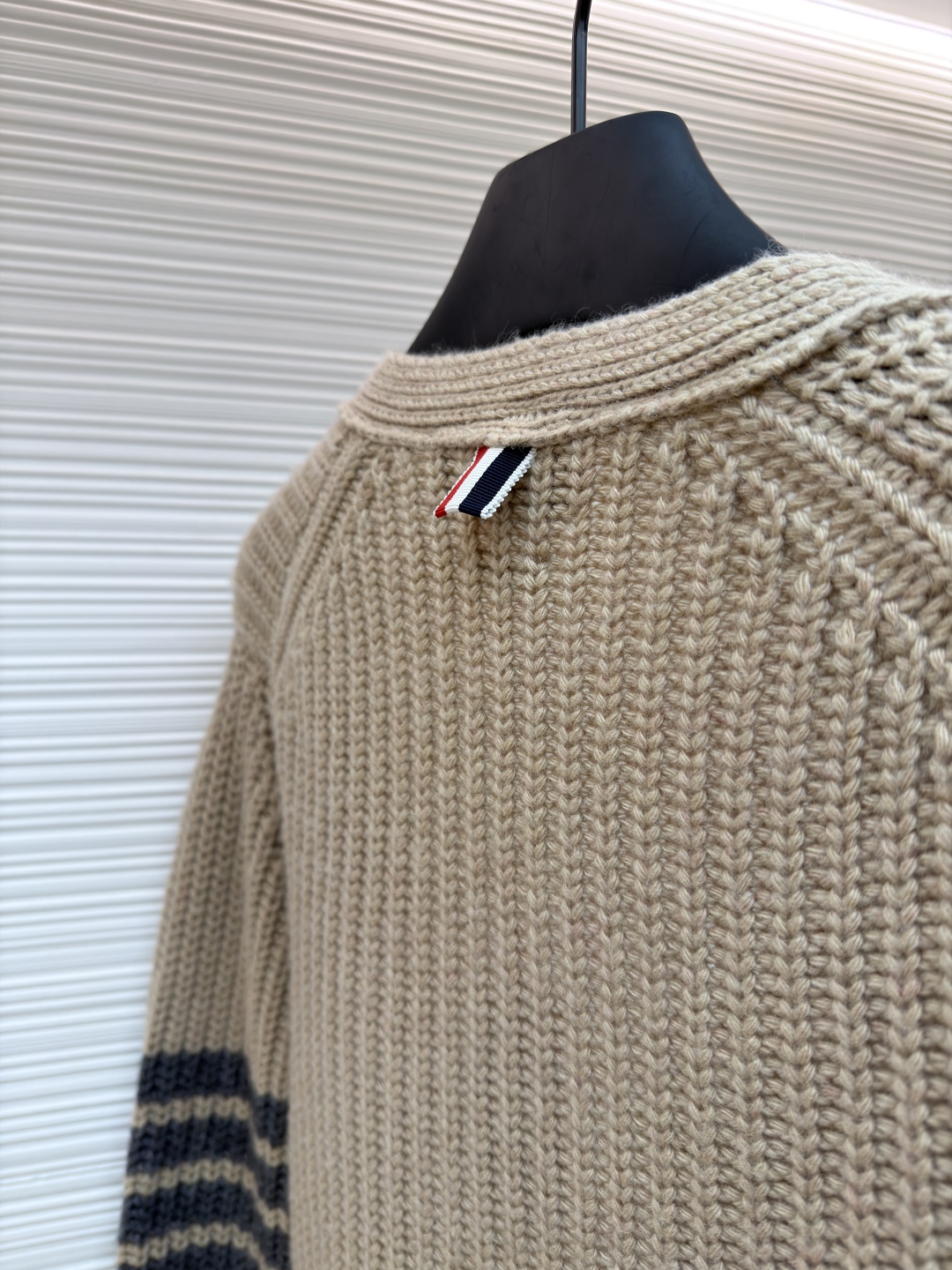 P365 THOM BROWNE四杠加厚元宝针开衫
●货号:1681466-C30
●面料:混纺面料
●工艺:针织制作
●颜色:驼色
●版型:宽松版型
●克重:约570克
●尺码:1-2-3-4
●描述:该开衫采用粗针针织工艺,选用质感细腻的纱线编织,衣身纹理粗犷且富有层次,营造出复古休闲的风格。细节工艺上,左臂的四条纹撞色针织工艺是品牌标志性设计,条纹与主色的搭配精准且富有辨识度;门襟与下摆的金属纽扣工艺,纽扣质感厚重,做工精细,既具实用性又提升了整体精致度;双贴袋的立体针织工艺,袋型挺括,与衣身针织纹理浑然一体。从粗针编织的整体质感,到条纹、纽扣、口袋的细节处理,每一处工艺都体现出品牌对经典风格与精湛工艺的坚持,打造出兼具辨识度与品质感的针织单品。整体走线平直细腻,面料舒适柔软,颜色一致无色差 能与同款搭配营造时尚造型,驾驭各种场合,定制辅料,三标齐全,男女同款!