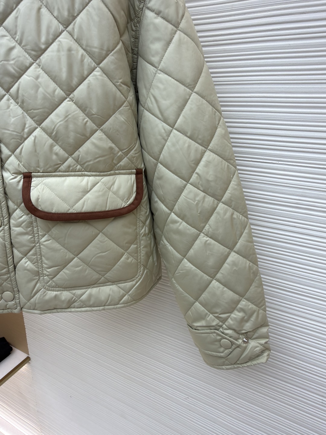 P315 MIU MIU菱格绣花夹克【女装】
●货号:1681468-B80
●面料:羊毛混纺面料
●工艺:绣花制作
●版型:合身版型
●克重:约480克
●尺码:S-M-L
●描述:这款宽松夹克以轻盈质感和柔软的Oversize版型脱颖而出采用绗缝工艺将外层布料和内芯直接缝合固定,这种工艺交叉严密,确保了外套的保暖性和耐用性,精确的菱格裁剪,并采用专业的缝合技术,确保每个菱格的形状和大小都一致,同时保证缝合处的平整和牢固,拼领等细节处,采用精细的手工缝制,确保每个细节都精致完美。同时,对外套的拉链、纽扣等配件进行严格的质量检查,确保其质量上乘,精选优质高弹棉, 内外全含棉, 面料是定制的, 口袋行线对格, 纽扣一比一开模定制, 内里全部包边, 细节强大 ,提升质感和高级感,具有一定的透气性,保暖性,轻便。羊绒混纺面的单色字母LOGO通过电脑绣花机高精度的计算系统控制机头、针杆、线轴的协同作业,布料框架在水平和垂直方向精准移动,形成针迹轨迹,调整上线和下线张力,确保线迹平整无浮线,形成误差在±0.1mm的精细字母图案。整体走线平直细腻,面料舒适柔软,颜色一致无色差 能与同款搭配营造时尚造型,驾驭各种场合,定制辅料,三标齐全,男女同款!