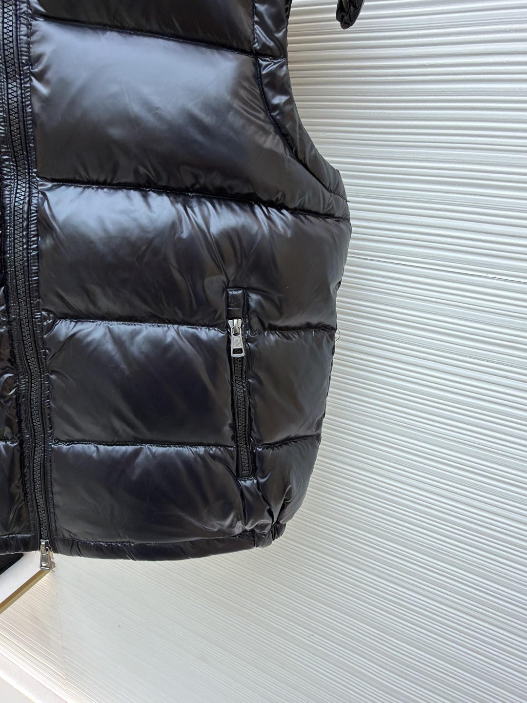 P255 MONCLER蒙口漆面布丁绗缝马甲
●原版:8899购入开发
●货号:1681475-B25
●面料:白鸭绒面料
●工艺:机械充绒制作
●颜色:黑色
●版型:合身版型
●克重:约745克
●尺码:1-2-3-4-5-6
●描述:该马甲采用高蓬松羽绒填充工艺,精选优质羽绒,保暖性优异且轻便。外层运用亮面涂层工艺,面料光泽感强,耐磨且易清洁;可拆卸连帽的精密缝制工艺,帽型挺括,满足不同穿搭需求。细节处,品牌徽标采用立体刺绣工艺,辨识度高;拉链与五金配件运用精细压铸工艺,顺滑耐用。整体采用分区绗缝工艺,走线工整,有效固定羽绒,避免跑绒。从羽绒填充的保暖性到亮面涂层的质感,每一处工艺都体现出品牌对户外功能性与时尚设计的双重追求,是一件兼具保暖与造型感的秋冬单品。整体走线平直细腻,面料舒适柔软,颜色一致无色差 能与同款搭配营造时尚造型,驾驭各种场合,定制辅料,三标齐全,男女同款!