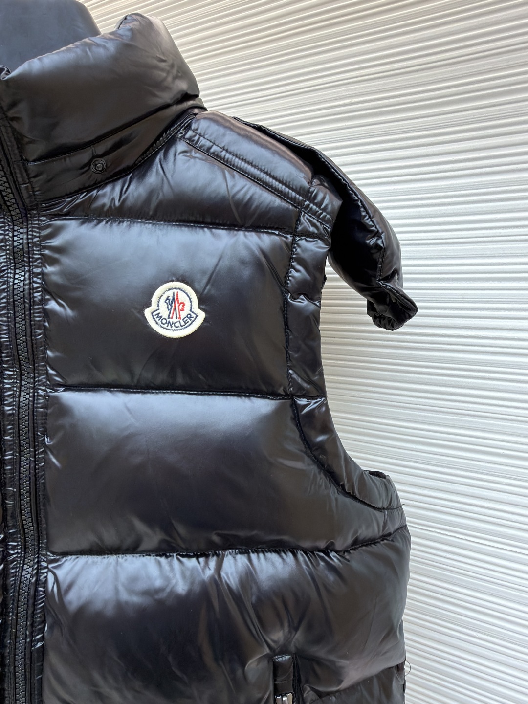 P255 MONCLER蒙口漆面布丁绗缝马甲
●原版:8899购入开发
●货号:1681475-B25
●面料:白鸭绒面料
●工艺:机械充绒制作
●颜色:黑色
●版型:合身版型
●克重:约745克
●尺码:1-2-3-4-5-6
●描述:该马甲采用高蓬松羽绒填充工艺,精选优质羽绒,保暖性优异且轻便。外层运用亮面涂层工艺,面料光泽感强,耐磨且易清洁;可拆卸连帽的精密缝制工艺,帽型挺括,满足不同穿搭需求。细节处,品牌徽标采用立体刺绣工艺,辨识度高;拉链与五金配件运用精细压铸工艺,顺滑耐用。整体采用分区绗缝工艺,走线工整,有效固定羽绒,避免跑绒。从羽绒填充的保暖性到亮面涂层的质感,每一处工艺都体现出品牌对户外功能性与时尚设计的双重追求,是一件兼具保暖与造型感的秋冬单品。整体走线平直细腻,面料舒适柔软,颜色一致无色差 能与同款搭配营造时尚造型,驾驭各种场合,定制辅料,三标齐全,男女同款!
