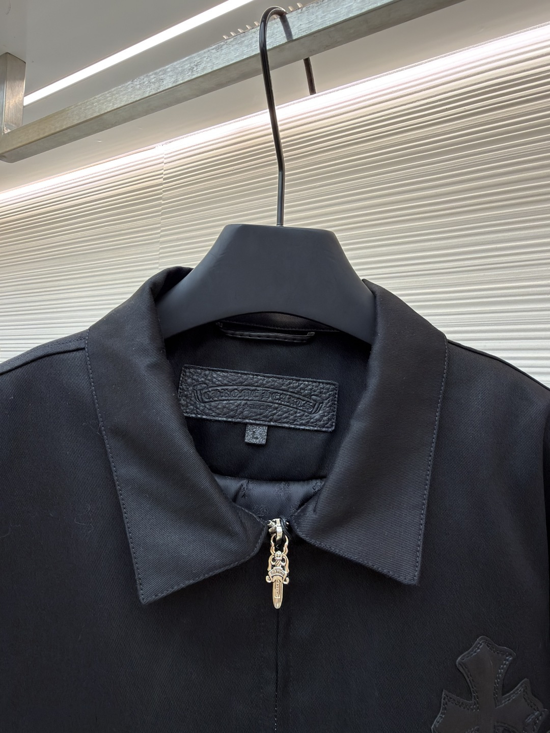 P310 Chrome Hearts 纯色Logo贴标翻领夹克
●原版：13730购入开发
●货号：1681764-B75
●面料：皮革面料
●工艺：贴布制作
●颜色：黑色
●版型：合身版型
●克重：约1020克
●尺码：S-M-L-XL
●描述：采用高密哑光面料，经防皱定型工艺处理，兼具挺括度与垂坠质感，触感顺滑且不易起球。衣身装饰品牌标志性十字刺绣，通过立体绗绣工艺打造，图案层次饱满、纹理清晰，兼具辨识度与精致度；袖口拼接皮质贴标，经热压贴合工艺固定，增强质感与耐用性。版型为宽松剪裁，搭配金属拉链+装饰吊坠，穿脱便捷且提升细节亮点；袖口纽扣调节设计适配不同臂围，下摆自然收边保障版型利落。全衣缝线工整，拼接处无外露线头，手工测量尺寸（误差1-3CM属正常），工艺平衡了暗黑风格与实穿属性，是兼具造型感与实用性的单品。整体走线平直细腻，面料舒适柔软，颜色一致无色差 能与同款搭配营造时尚造型，驾驭各种场合，定制辅料，三标齐全，男女同款！