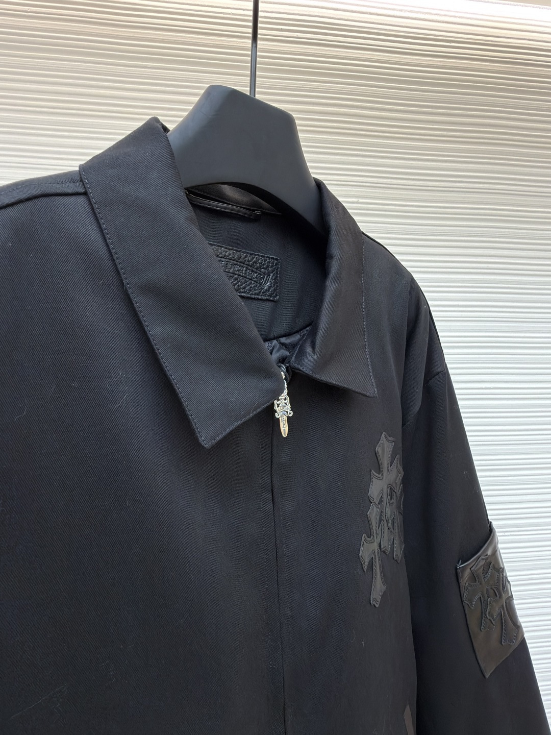 P310 Chrome Hearts 纯色Logo贴标翻领夹克
●原版：13730购入开发
●货号：1681764-B75
●面料：皮革面料
●工艺：贴布制作
●颜色：黑色
●版型：合身版型
●克重：约1020克
●尺码：S-M-L-XL
●描述：采用高密哑光面料，经防皱定型工艺处理，兼具挺括度与垂坠质感，触感顺滑且不易起球。衣身装饰品牌标志性十字刺绣，通过立体绗绣工艺打造，图案层次饱满、纹理清晰，兼具辨识度与精致度；袖口拼接皮质贴标，经热压贴合工艺固定，增强质感与耐用性。版型为宽松剪裁，搭配金属拉链+装饰吊坠，穿脱便捷且提升细节亮点；袖口纽扣调节设计适配不同臂围，下摆自然收边保障版型利落。全衣缝线工整，拼接处无外露线头，手工测量尺寸（误差1-3CM属正常），工艺平衡了暗黑风格与实穿属性，是兼具造型感与实用性的单品。整体走线平直细腻，面料舒适柔软，颜色一致无色差 能与同款搭配营造时尚造型，驾驭各种场合，定制辅料，三标齐全，男女同款！