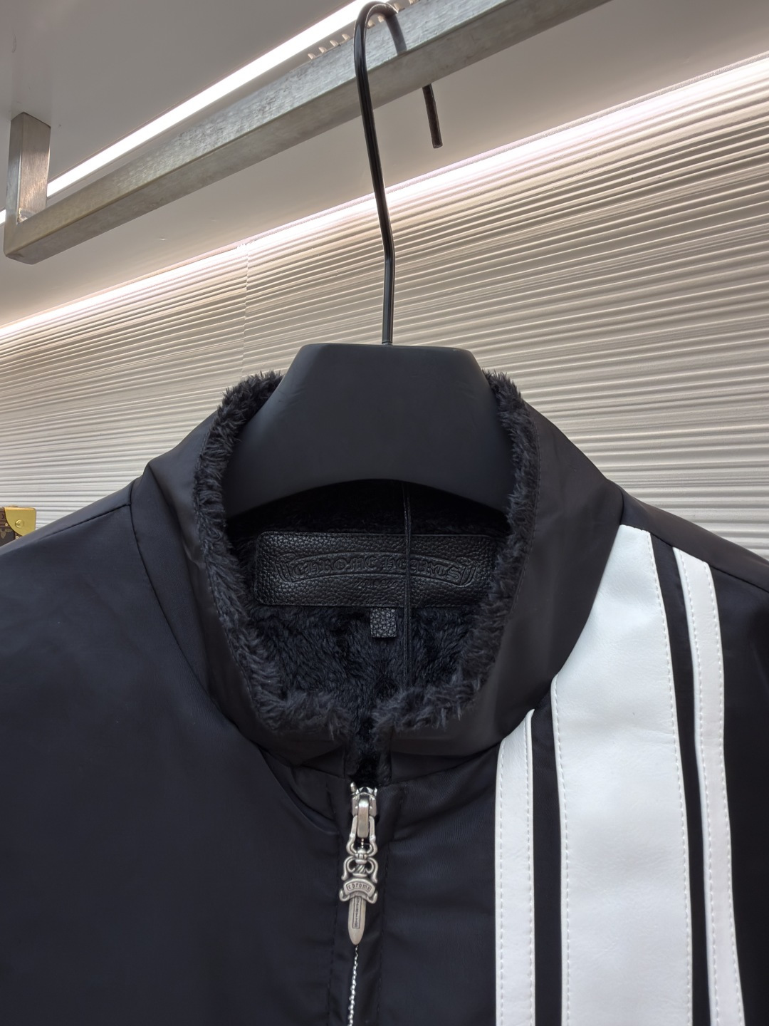 P295 Chrome Hearts 贴布条纹夹克
●原版：30000购入开发
●货号：1681765-B60
●面料：聚酯纤维面料
●工艺：贴布制作
●颜色：黑色
●版型：合身版型
●克重：约680克
●尺码：S-M-L-XL
●描述：采用高密防风面料，经防泼水涂层处理，兼具耐用性与防护性，触感顺滑且不易起皱。衣身侧边拼接黑白条纹装饰，通过精准定位缝制工艺固定，线条规整增强视觉层次；正面装饰品牌红色Logo印花，采用高温烫印工艺，色彩饱和且不易脱落，凸显辨识度。版型为宽松剪裁，搭配金属拉链开合，穿脱便捷；罗纹领口、袖口及下摆增强贴合度，兼顾防风性与休闲感。全衣缝线工整，拼接处无外露线头，手工测量尺寸（误差1-3CM属正常），工艺平衡了街头风格与品牌标志性设计，是兼具实穿性与潮流感的单品。整体走线平直细腻，面料舒适柔软，颜色一致无色差 能与同款搭配营造时尚造型，驾驭各种场合，定制辅料，三标齐全，男女同款！