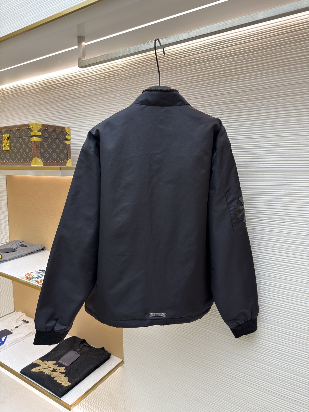 P295 Chrome Hearts 贴布条纹夹克
●原版：30000购入开发
●货号：1681765-B60
●面料：聚酯纤维面料
●工艺：贴布制作
●颜色：黑色
●版型：合身版型
●克重：约680克
●尺码：S-M-L-XL
●描述：采用高密防风面料，经防泼水涂层处理，兼具耐用性与防护性，触感顺滑且不易起皱。衣身侧边拼接黑白条纹装饰，通过精准定位缝制工艺固定，线条规整增强视觉层次；正面装饰品牌红色Logo印花，采用高温烫印工艺，色彩饱和且不易脱落，凸显辨识度。版型为宽松剪裁，搭配金属拉链开合，穿脱便捷；罗纹领口、袖口及下摆增强贴合度，兼顾防风性与休闲感。全衣缝线工整，拼接处无外露线头，手工测量尺寸（误差1-3CM属正常），工艺平衡了街头风格与品牌标志性设计，是兼具实穿性与潮流感的单品。整体走线平直细腻，面料舒适柔软，颜色一致无色差 能与同款搭配营造时尚造型，驾驭各种场合，定制辅料，三标齐全，男女同款！