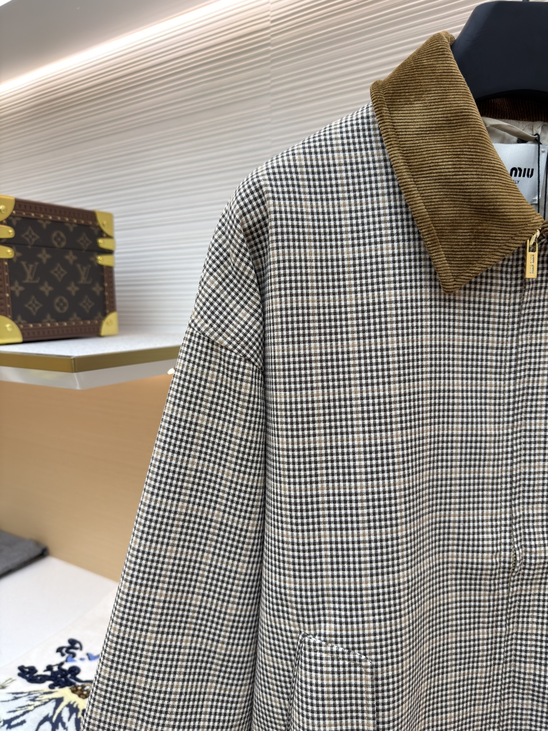 P285 MIU MIU千鸟格拼色外套
●原版：10329购入开发
●货号：1681768-B50
●面料：全棉面料
●工艺：压印制作
●版型：合身版型
●克重：约725克
●尺码：36-38-40-42
●描述：采用千鸟格混纺面料，经预缩定型工艺处理，保障版型挺括且不易变形，触感柔软兼具质感。领口拼接灯芯绒材质，通过恒温复合工艺固定，纹理饱满增强复古氛围；衣身装饰品牌暗纹标识，采用压印工艺打造，低调精致且辨识度高。版型为宽松剪裁，适配多元身形，搭配拉链+纽扣双重开合，穿脱便捷；下摆抽绳设计可调节版型，袖口简约收边兼顾利落感。全衣缝线工整，拼接处无外露线头，手工测量尺寸（误差1-3CM属正常），工艺平衡了复古格纹与甜酷风格，是兼具实穿性与造型感的单品。整体走线平直细腻，面料舒适柔软，颜色一致无色差 能与同款搭配营造时尚造型，驾驭各种场合，定制辅料，三标齐全，男女同款！