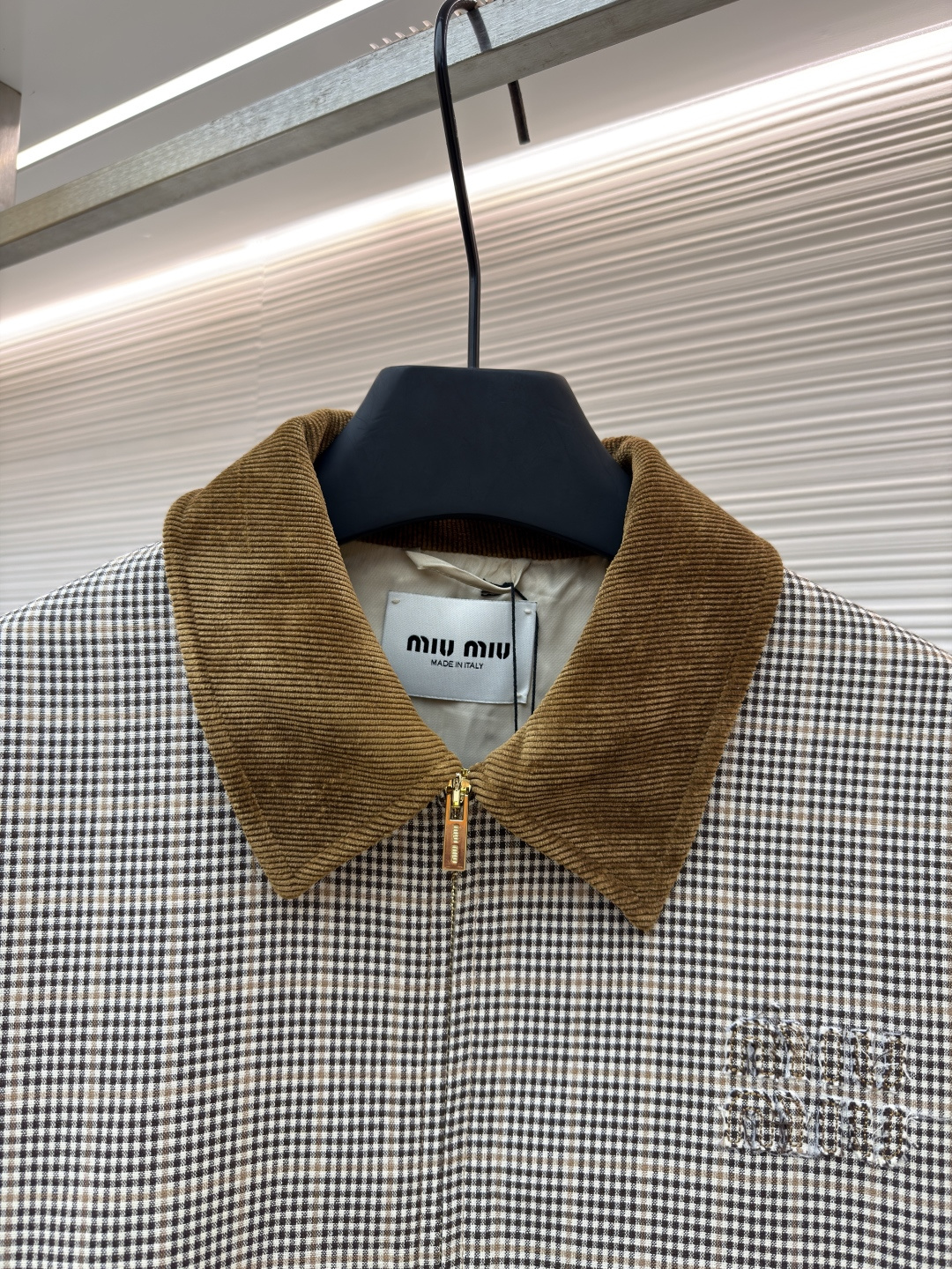 P285 MIU MIU千鸟格拼色外套
●原版：10329购入开发
●货号：1681768-B50
●面料：全棉面料
●工艺：压印制作
●版型：合身版型
●克重：约725克
●尺码：36-38-40-42
●描述：采用千鸟格混纺面料，经预缩定型工艺处理，保障版型挺括且不易变形，触感柔软兼具质感。领口拼接灯芯绒材质，通过恒温复合工艺固定，纹理饱满增强复古氛围；衣身装饰品牌暗纹标识，采用压印工艺打造，低调精致且辨识度高。版型为宽松剪裁，适配多元身形，搭配拉链+纽扣双重开合，穿脱便捷；下摆抽绳设计可调节版型，袖口简约收边兼顾利落感。全衣缝线工整，拼接处无外露线头，手工测量尺寸（误差1-3CM属正常），工艺平衡了复古格纹与甜酷风格，是兼具实穿性与造型感的单品。整体走线平直细腻，面料舒适柔软，颜色一致无色差 能与同款搭配营造时尚造型，驾驭各种场合，定制辅料，三标齐全，男女同款！