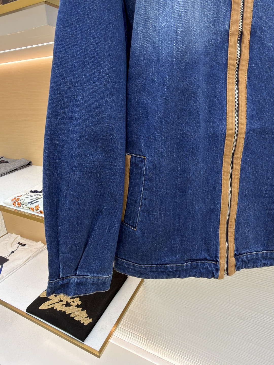 P280 MIU MIU皮革饰边牛仔外套 
●原版：16708购入开发
●货号：1681771-B45
●面料：牛仔面料
●工艺：立体绣线制作
●颜色：蓝色
●版型：合身版型
●克重：约1085克
●尺码：S-M-L
●描述：采用做旧水洗牛仔面料，经石磨工艺处理，呈现自然渐变色泽，触感柔软且保留牛仔挺括质感。衣身拼接棕褐色皮质饰条，通过精密车缝工艺固定，纹理细腻增强复古层次；胸前装饰品牌字母刺绣，采用立体绣线工艺，线条清晰且不易脱落，凸显辨识度。版型为宽松剪裁，适配多元身形，拉链开合搭配翻领设计，穿脱便捷且适配多场景；袖口、下摆采用牛仔原边收缝，保障版型利落度。全衣缝线工整，拼接处无外露线头，手工测量尺寸（误差1-3CM属正常），工艺平衡了复古牛仔与甜酷风格，是兼具实穿性与造型感的单品。整体走线平直细腻，面料舒适柔软，颜色一致无色差 能与同款搭配营造时尚造型，驾驭各种场合，定制辅料，三标齐全，男女同款！