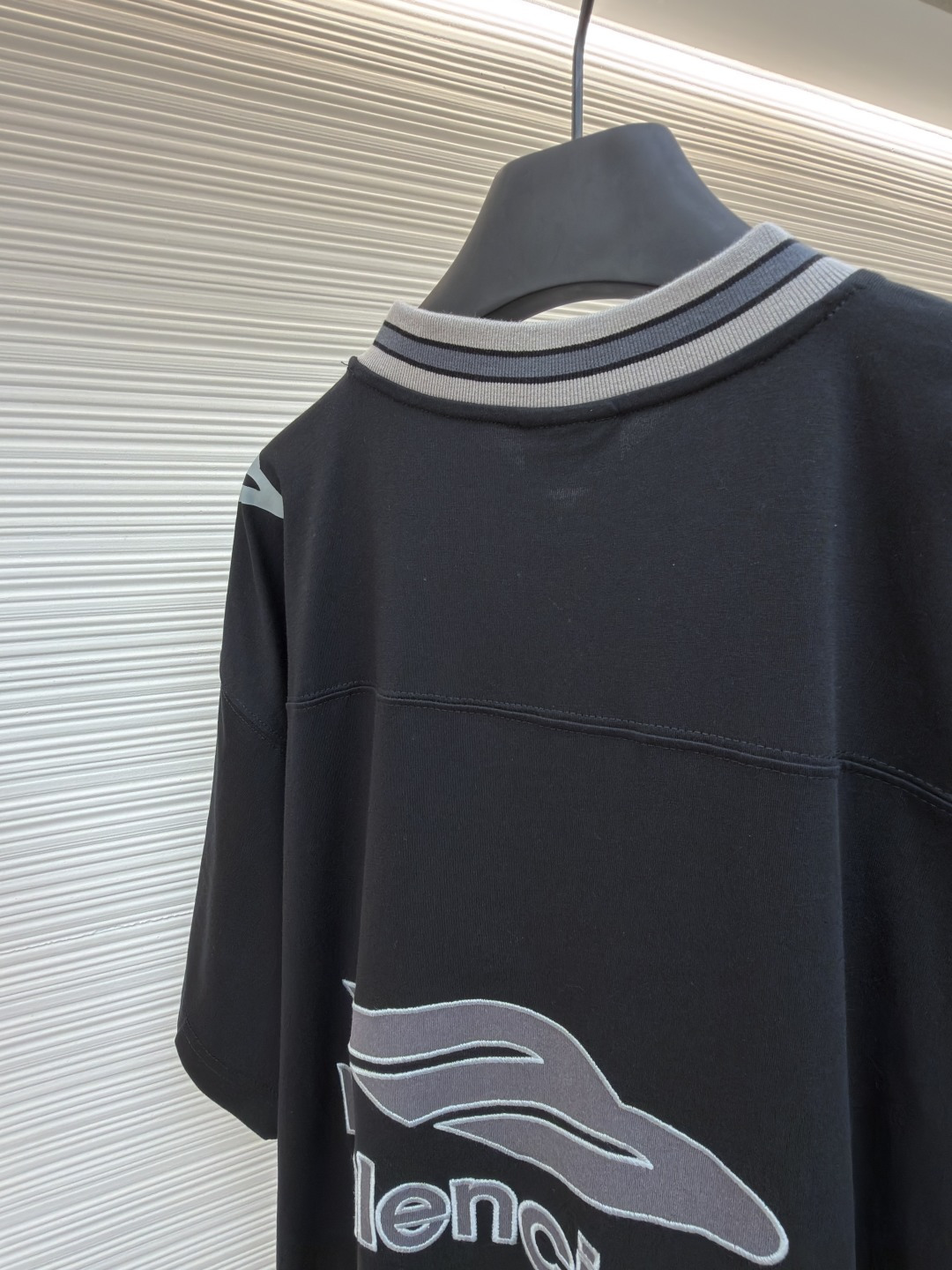 P180 Balenciaga 球队系列V领长袖
●原版：6898购入开发
●货号：1682042-A50
●面料：平纹针织紧密棉面料
●工艺：胶浆印花制作
●颜色：黑色
●版型：宽松版型
●克重：约310克
●尺码：XS-S-M-L
●描述：主体采用24支特纺紧密棉，克重为185g/㎡。在纺纱环节应用了紧密纺技术，显著减少了纱线毛羽，使得纱线更光滑、强韧。这赋予了面料结构异常密实、表面光洁平整、抗起球性优异的特点，同时保留了纯棉的柔软透气性。185g的克重属于轻至中量级，确保了衣物轻盈、垂坠且活动自如的特性，非常适合打造兼具运动感与日常舒适度的长袖衫。V领部分由两种不同颜色的高弹罗纹面料拼接而成。其工艺步骤是先分别织造出两种颜色的罗纹带，再通过精准的剪裁与拼接，形成具有鲜明色彩对比的V形领口。打破了纯色衣身的单调，以强烈的色彩对比塑造出年轻、活力的视觉焦点，并优化了颈部线。将图案在不同材质或颜色的布料上预先裁剪成型贴布，然后将其覆盖在衣身上，最后用高密度绣线锁边固定并勾勒内部细节。其作用在于：创造色彩鲜明、质感对比强烈且极具立体感和耐用性的图案，图案边缘牢固，不易磨损。将特制的弹性浆料通过网版印刷在袖部的工艺，色彩鲜艳且具有轻微涂层感的图案。弹力浆料保证了印花区域能随面料一起拉伸而不开裂。与贴布绣的立体感形成一平一凸的质感对比，增加了设计的趣味性和复杂度。整体走线平直细腻，面料舒适柔软，颜色一致无色差 能与同款搭配营造时尚造型，驾驭各种场合，定制辅料，三标齐全，男女同款！