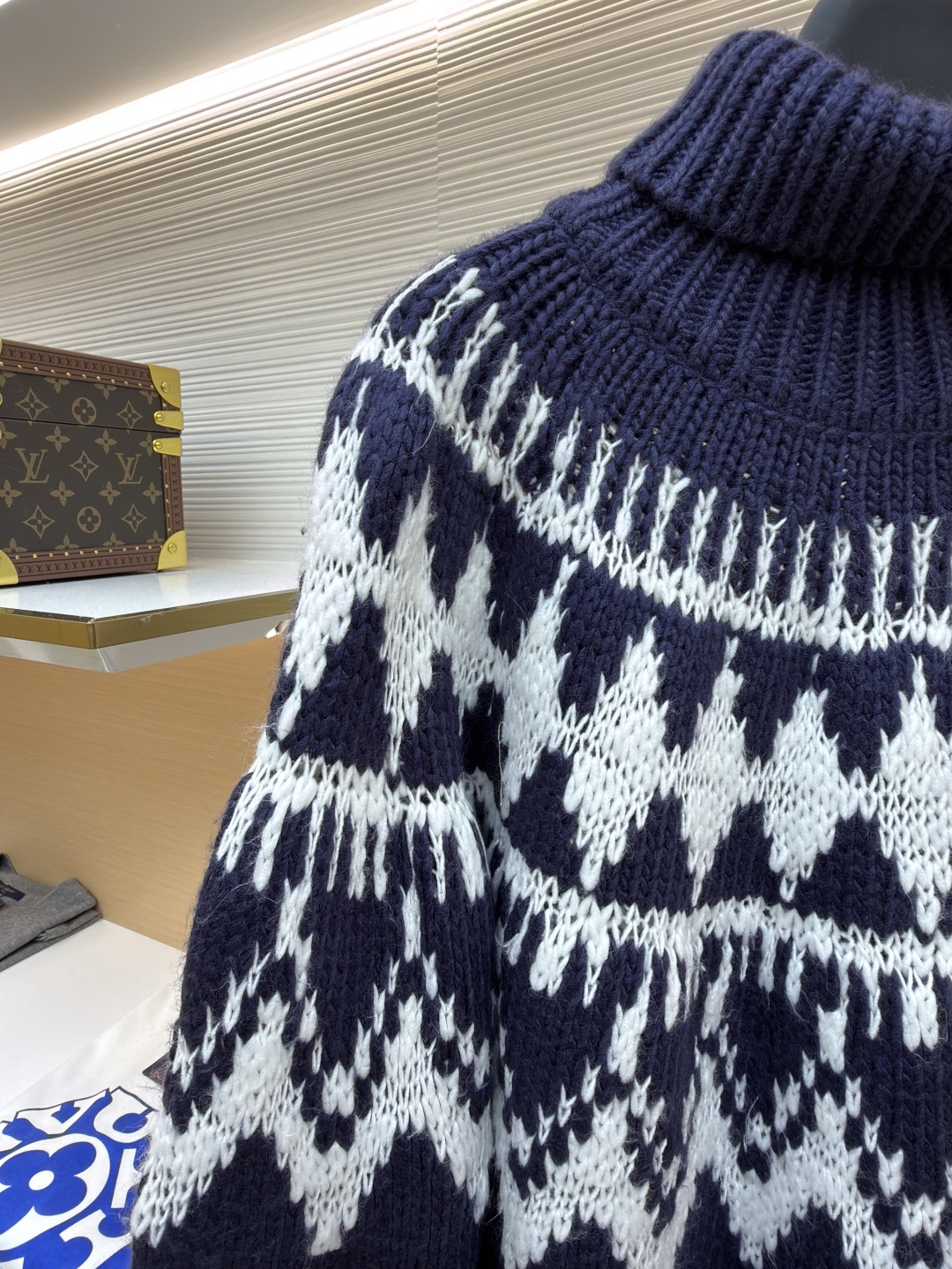 P250 Dior 提花高领毛衣
●原版：18000购入开发
●货号：1682045-B20
●面料：羊毛面料
●工艺：提花针织制作
●颜色：蓝白
●版型：合身版型
●克重：约1055克
●尺码：S-M-L-XL
●描述：定织雅绒蓝白绵羊毛针织锦 质感十足 厚重扎实 每一寸纤维都蕴含着沉甸甸的暖意 当这抹深邃的蓝遇上纯净的白色 纯净而优雅 饰以灵感源自冬季运动世界的 Fair Isle 图案点缀其间 带着一种冬日独有的静谧与诗意 精致的几何纹路营造出一种神秘而优雅的氛围 背面精心饰以的CD标志 宛如时尚殿堂的徽章 奢华的象征 与生俱来的高贵气质 让每一个瞬间都散发出典雅与时尚交织的迷人魅。德国进口机提花组织而成 精确地控制纱线的排列和交织方式 在织机上精心交织  Fair Isle图案以及CD 提花艺术图案镶饰 织物更加生动立体，曲型螺纹组织 通过改变针织过程中的针法和纱线的排列方式 使纱线在织物中呈现出曲线状的分布，成衣洗水加软去味工艺 通过专业的洗涤设备和特定的洗涤剂 对衣物进行深度清洁和去味处理 改善衣物的手感和外观。整体走线平直细腻，面料舒适柔软，颜色一致无色差 能与同款搭配营造时尚造型，驾驭各种场合，定制辅料，三标齐全，男女同款！