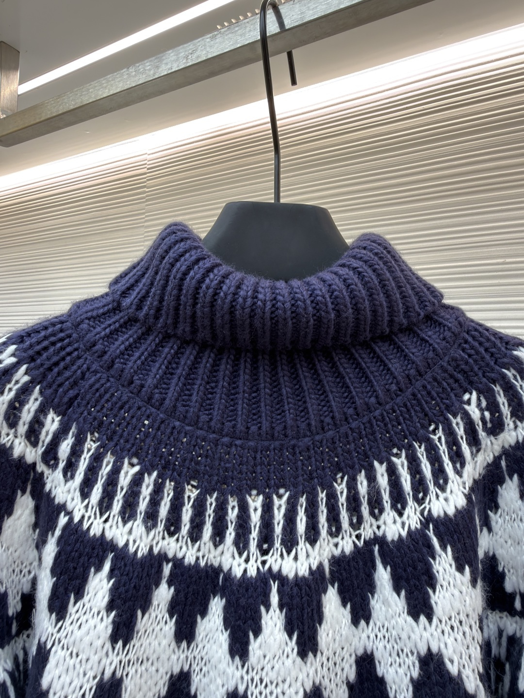 P250 Dior 提花高领毛衣
●原版：18000购入开发
●货号：1682045-B20
●面料：羊毛面料
●工艺：提花针织制作
●颜色：蓝白
●版型：合身版型
●克重：约1055克
●尺码：S-M-L-XL
●描述：定织雅绒蓝白绵羊毛针织锦 质感十足 厚重扎实 每一寸纤维都蕴含着沉甸甸的暖意 当这抹深邃的蓝遇上纯净的白色 纯净而优雅 饰以灵感源自冬季运动世界的 Fair Isle 图案点缀其间 带着一种冬日独有的静谧与诗意 精致的几何纹路营造出一种神秘而优雅的氛围 背面精心饰以的CD标志 宛如时尚殿堂的徽章 奢华的象征 与生俱来的高贵气质 让每一个瞬间都散发出典雅与时尚交织的迷人魅。德国进口机提花组织而成 精确地控制纱线的排列和交织方式 在织机上精心交织  Fair Isle图案以及CD 提花艺术图案镶饰 织物更加生动立体，曲型螺纹组织 通过改变针织过程中的针法和纱线的排列方式 使纱线在织物中呈现出曲线状的分布，成衣洗水加软去味工艺 通过专业的洗涤设备和特定的洗涤剂 对衣物进行深度清洁和去味处理 改善衣物的手感和外观。整体走线平直细腻，面料舒适柔软，颜色一致无色差 能与同款搭配营造时尚造型，驾驭各种场合，定制辅料，三标齐全，男女同款！