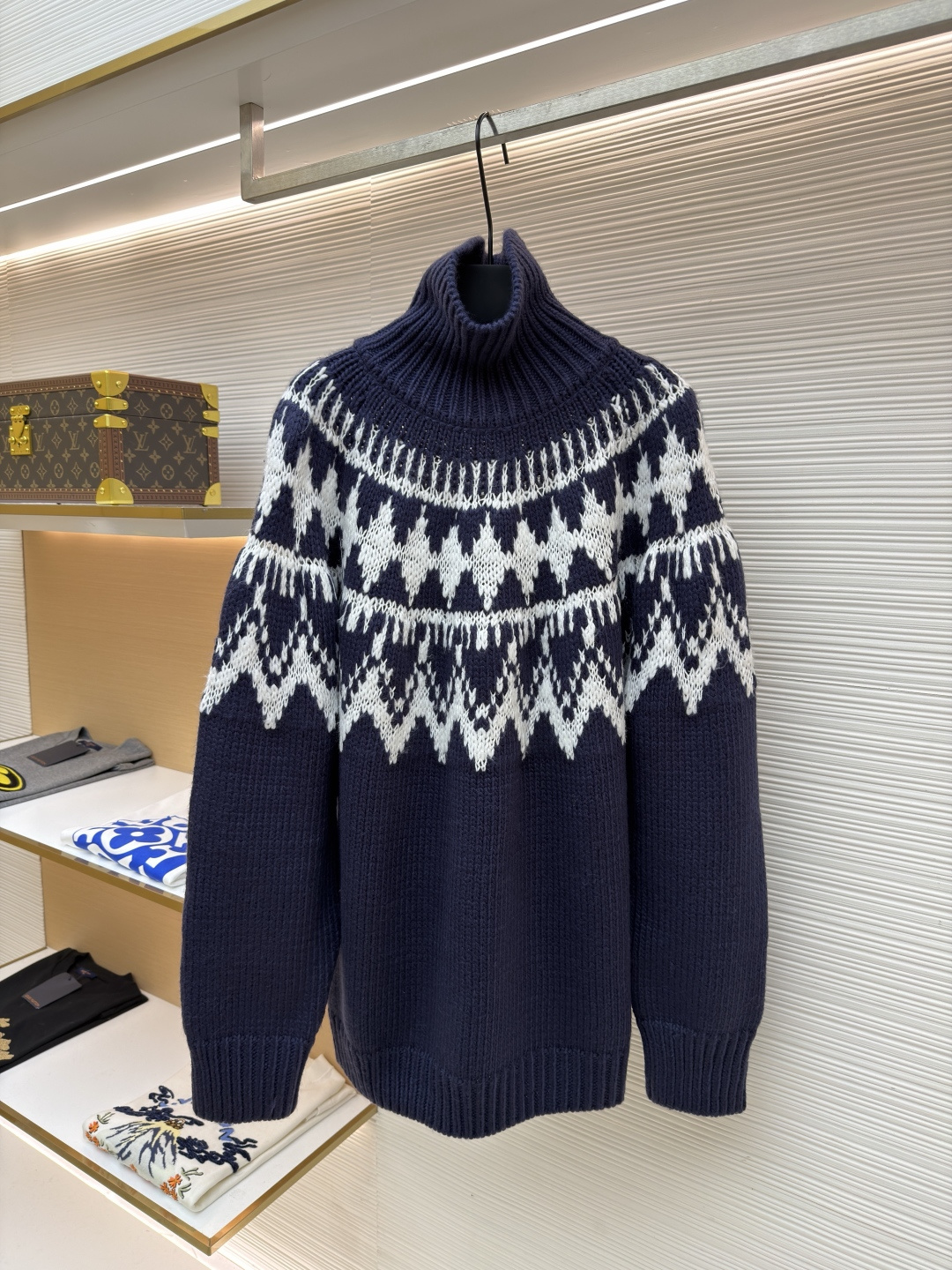 P250 Dior 提花高领毛衣
●原版：18000购入开发
●货号：1682045-B20
●面料：羊毛面料
●工艺：提花针织制作
●颜色：蓝白
●版型：合身版型
●克重：约1055克
●尺码：S-M-L-XL
●描述：定织雅绒蓝白绵羊毛针织锦 质感十足 厚重扎实 每一寸纤维都蕴含着沉甸甸的暖意 当这抹深邃的蓝遇上纯净的白色 纯净而优雅 饰以灵感源自冬季运动世界的 Fair Isle 图案点缀其间 带着一种冬日独有的静谧与诗意 精致的几何纹路营造出一种神秘而优雅的氛围 背面精心饰以的CD标志 宛如时尚殿堂的徽章 奢华的象征 与生俱来的高贵气质 让每一个瞬间都散发出典雅与时尚交织的迷人魅。德国进口机提花组织而成 精确地控制纱线的排列和交织方式 在织机上精心交织  Fair Isle图案以及CD 提花艺术图案镶饰 织物更加生动立体，曲型螺纹组织 通过改变针织过程中的针法和纱线的排列方式 使纱线在织物中呈现出曲线状的分布，成衣洗水加软去味工艺 通过专业的洗涤设备和特定的洗涤剂 对衣物进行深度清洁和去味处理 改善衣物的手感和外观。整体走线平直细腻，面料舒适柔软，颜色一致无色差 能与同款搭配营造时尚造型，驾驭各种场合，定制辅料，三标齐全，男女同款！