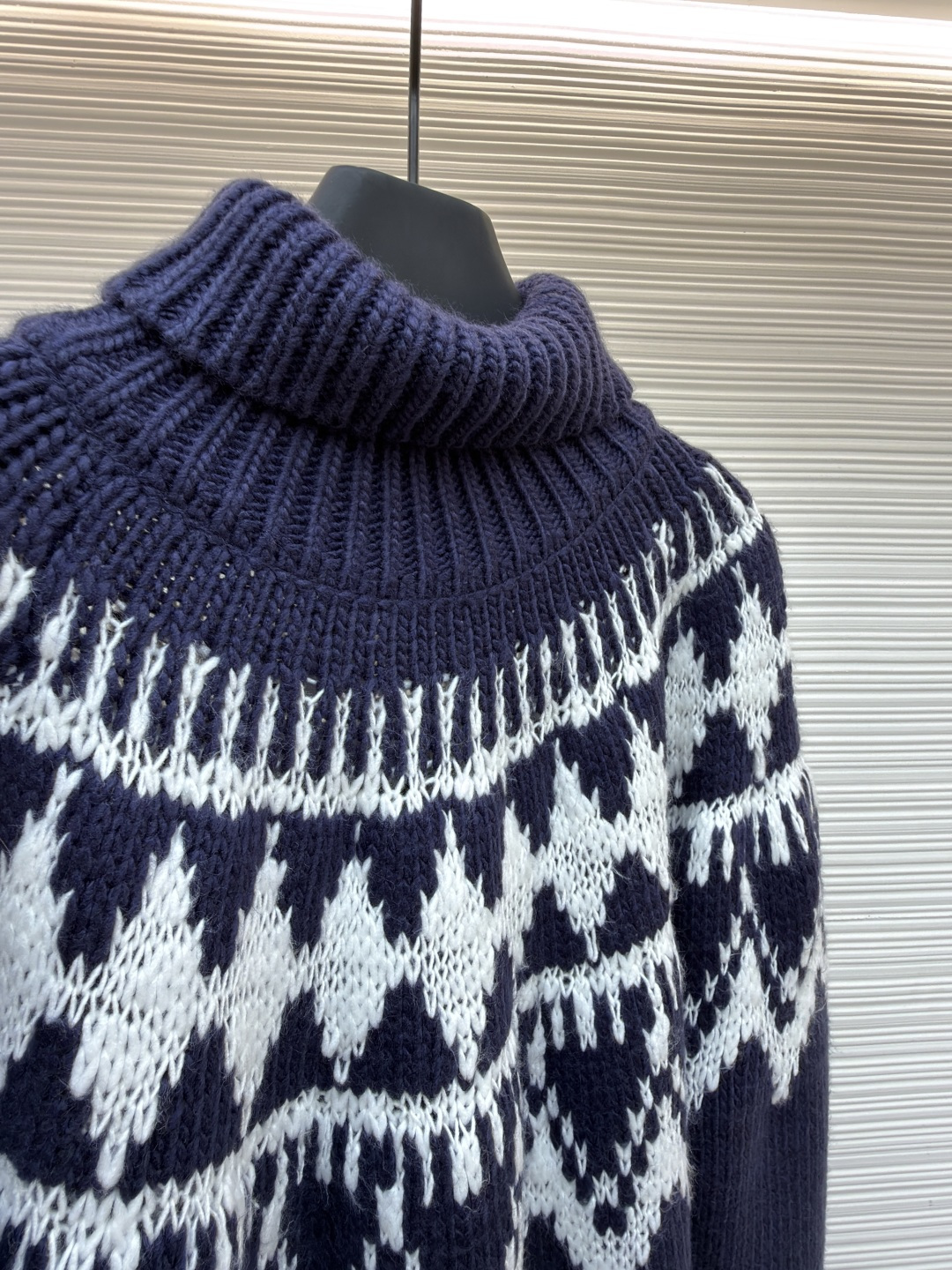 P250 Dior 提花高领毛衣
●原版：18000购入开发
●货号：1682045-B20
●面料：羊毛面料
●工艺：提花针织制作
●颜色：蓝白
●版型：合身版型
●克重：约1055克
●尺码：S-M-L-XL
●描述：定织雅绒蓝白绵羊毛针织锦 质感十足 厚重扎实 每一寸纤维都蕴含着沉甸甸的暖意 当这抹深邃的蓝遇上纯净的白色 纯净而优雅 饰以灵感源自冬季运动世界的 Fair Isle 图案点缀其间 带着一种冬日独有的静谧与诗意 精致的几何纹路营造出一种神秘而优雅的氛围 背面精心饰以的CD标志 宛如时尚殿堂的徽章 奢华的象征 与生俱来的高贵气质 让每一个瞬间都散发出典雅与时尚交织的迷人魅。德国进口机提花组织而成 精确地控制纱线的排列和交织方式 在织机上精心交织  Fair Isle图案以及CD 提花艺术图案镶饰 织物更加生动立体，曲型螺纹组织 通过改变针织过程中的针法和纱线的排列方式 使纱线在织物中呈现出曲线状的分布，成衣洗水加软去味工艺 通过专业的洗涤设备和特定的洗涤剂 对衣物进行深度清洁和去味处理 改善衣物的手感和外观。整体走线平直细腻，面料舒适柔软，颜色一致无色差 能与同款搭配营造时尚造型，驾驭各种场合，定制辅料，三标齐全，男女同款！