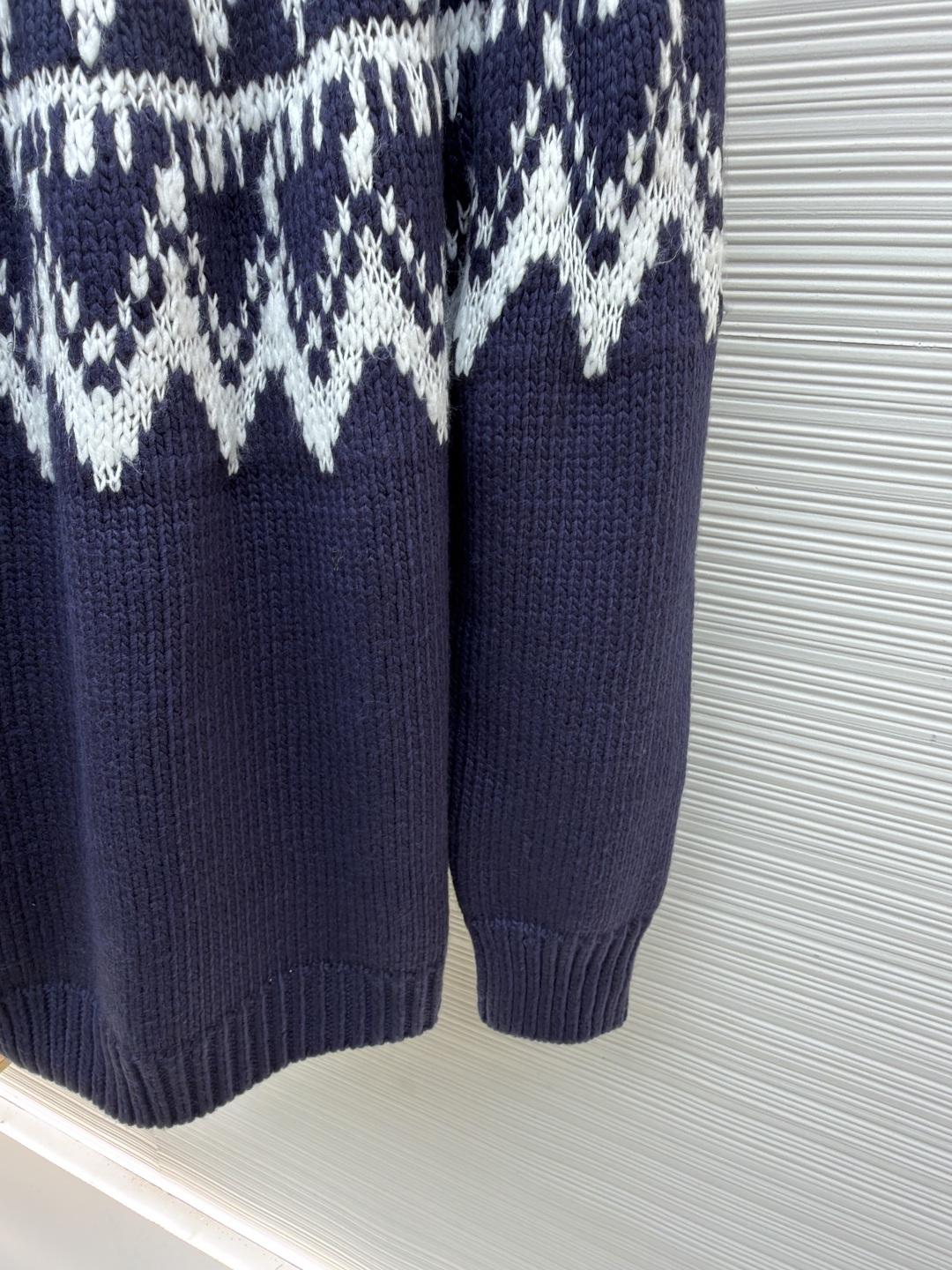 P250 Dior 提花高领毛衣
●原版：18000购入开发
●货号：1682045-B20
●面料：羊毛面料
●工艺：提花针织制作
●颜色：蓝白
●版型：合身版型
●克重：约1055克
●尺码：S-M-L-XL
●描述：定织雅绒蓝白绵羊毛针织锦 质感十足 厚重扎实 每一寸纤维都蕴含着沉甸甸的暖意 当这抹深邃的蓝遇上纯净的白色 纯净而优雅 饰以灵感源自冬季运动世界的 Fair Isle 图案点缀其间 带着一种冬日独有的静谧与诗意 精致的几何纹路营造出一种神秘而优雅的氛围 背面精心饰以的CD标志 宛如时尚殿堂的徽章 奢华的象征 与生俱来的高贵气质 让每一个瞬间都散发出典雅与时尚交织的迷人魅。德国进口机提花组织而成 精确地控制纱线的排列和交织方式 在织机上精心交织  Fair Isle图案以及CD 提花艺术图案镶饰 织物更加生动立体，曲型螺纹组织 通过改变针织过程中的针法和纱线的排列方式 使纱线在织物中呈现出曲线状的分布，成衣洗水加软去味工艺 通过专业的洗涤设备和特定的洗涤剂 对衣物进行深度清洁和去味处理 改善衣物的手感和外观。整体走线平直细腻，面料舒适柔软，颜色一致无色差 能与同款搭配营造时尚造型，驾驭各种场合，定制辅料，三标齐全，男女同款！