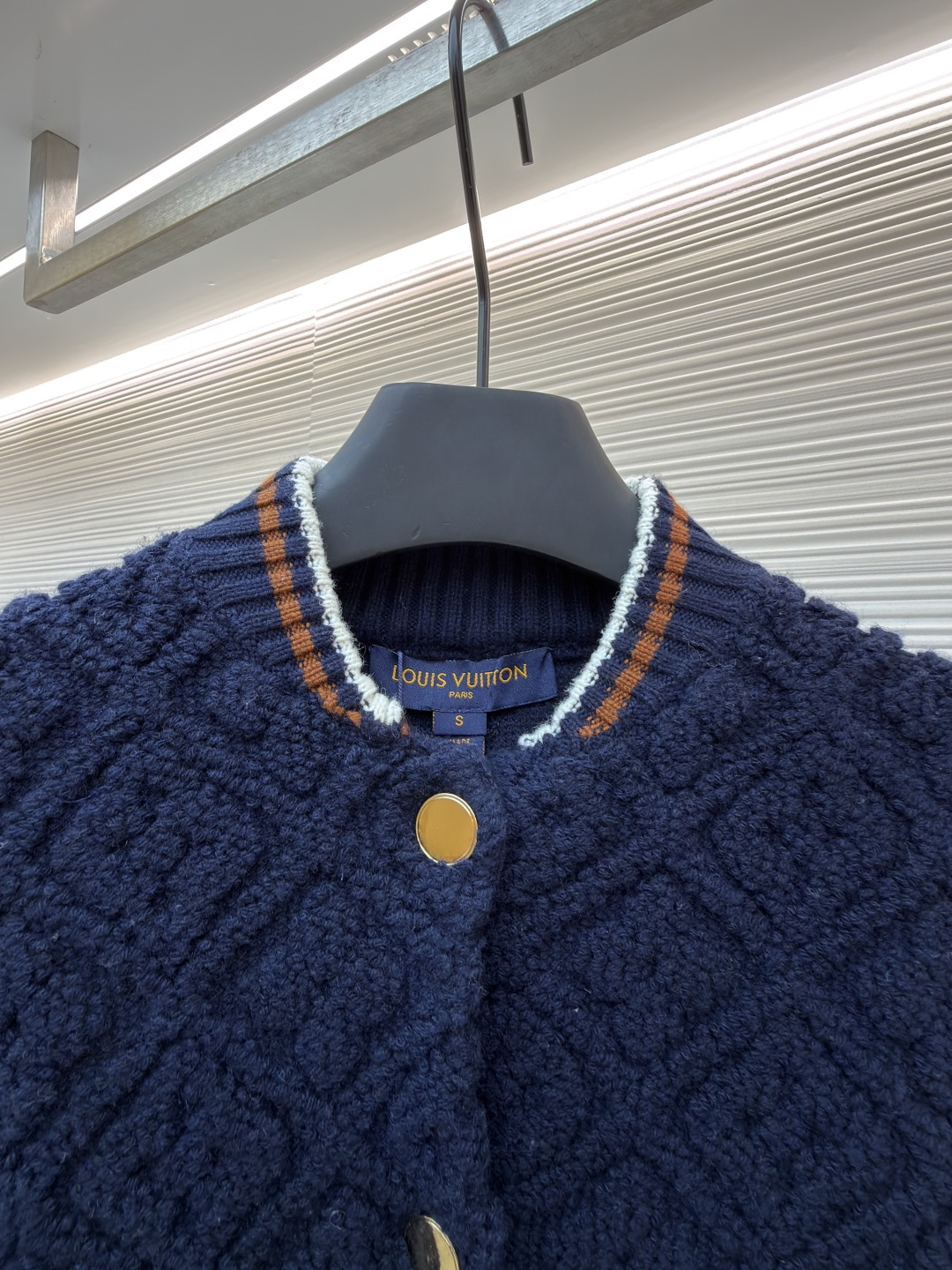 P815 LOUIS VUITTON SKI滑雪系列拼色条纹棒球长袖外套
●原版：22999购入开发
●面料：羊毛混纺面料
●工艺：针织制作
●颜色：蓝白
●版型：合身版型
●克重：约1070克
●尺码：XS-S-M-L
●描述：这款路易威登拼色针织开衫采用立体绞花编织工艺打造主体衣身，选用高支数美利奴羊毛混纺面料，通过双针床针织机织造出凹凸有致的菱格纹理，每平方厘米编织密度达32针，让纹理兼具立体感与柔软度；衣身主体为藏青色定纺纱线，经三次水洗固色处理，有效防止褪色。袖子部分采用米白色竖坑条罗纹针织，单股纱线捻度控制在800捻/米，保证回弹性与贴合度。金属按扣为定制黄铜材质，经镀金封釉工艺处理；领口、下摆的撞色罗纹采用嵌花编织，精准对接品牌经典三色织带比例，袖口处还暗藏激光雕刻的品牌标识，整体工艺融合传统针织技法与现代精工，细节处尽显匠造水准。整体走线平直细腻，面料舒适柔软，颜色一致无色差 能与同款搭配营造时尚造型，驾驭各种场合，定制辅料，三标齐全，男女同款！