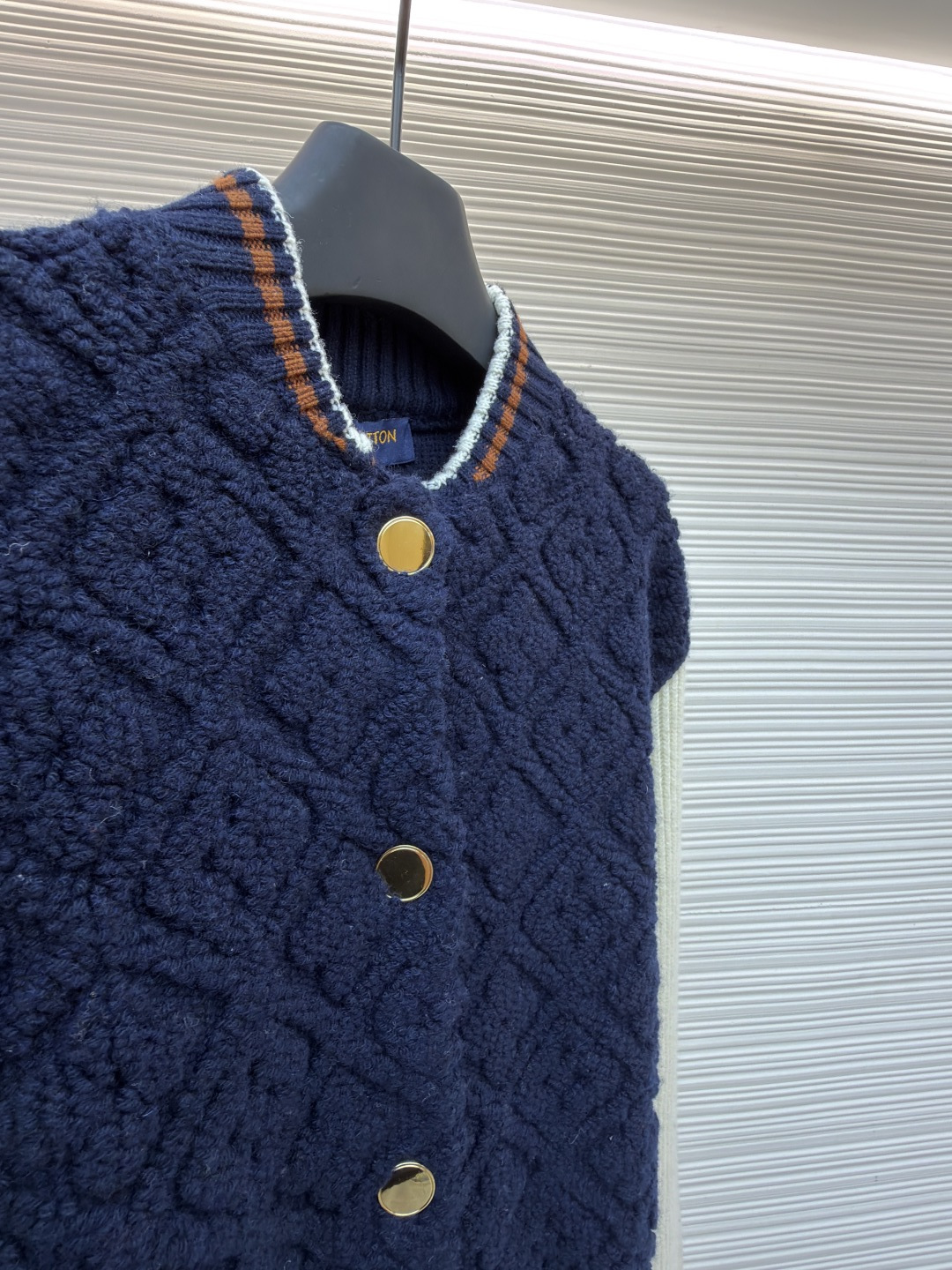 P815 LOUIS VUITTON SKI滑雪系列拼色条纹棒球长袖外套
●原版：22999购入开发
●面料：羊毛混纺面料
●工艺：针织制作
●颜色：蓝白
●版型：合身版型
●克重：约1070克
●尺码：XS-S-M-L
●描述：这款路易威登拼色针织开衫采用立体绞花编织工艺打造主体衣身，选用高支数美利奴羊毛混纺面料，通过双针床针织机织造出凹凸有致的菱格纹理，每平方厘米编织密度达32针，让纹理兼具立体感与柔软度；衣身主体为藏青色定纺纱线，经三次水洗固色处理，有效防止褪色。袖子部分采用米白色竖坑条罗纹针织，单股纱线捻度控制在800捻/米，保证回弹性与贴合度。金属按扣为定制黄铜材质，经镀金封釉工艺处理；领口、下摆的撞色罗纹采用嵌花编织，精准对接品牌经典三色织带比例，袖口处还暗藏激光雕刻的品牌标识，整体工艺融合传统针织技法与现代精工，细节处尽显匠造水准。整体走线平直细腻，面料舒适柔软，颜色一致无色差 能与同款搭配营造时尚造型，驾驭各种场合，定制辅料，三标齐全，男女同款！