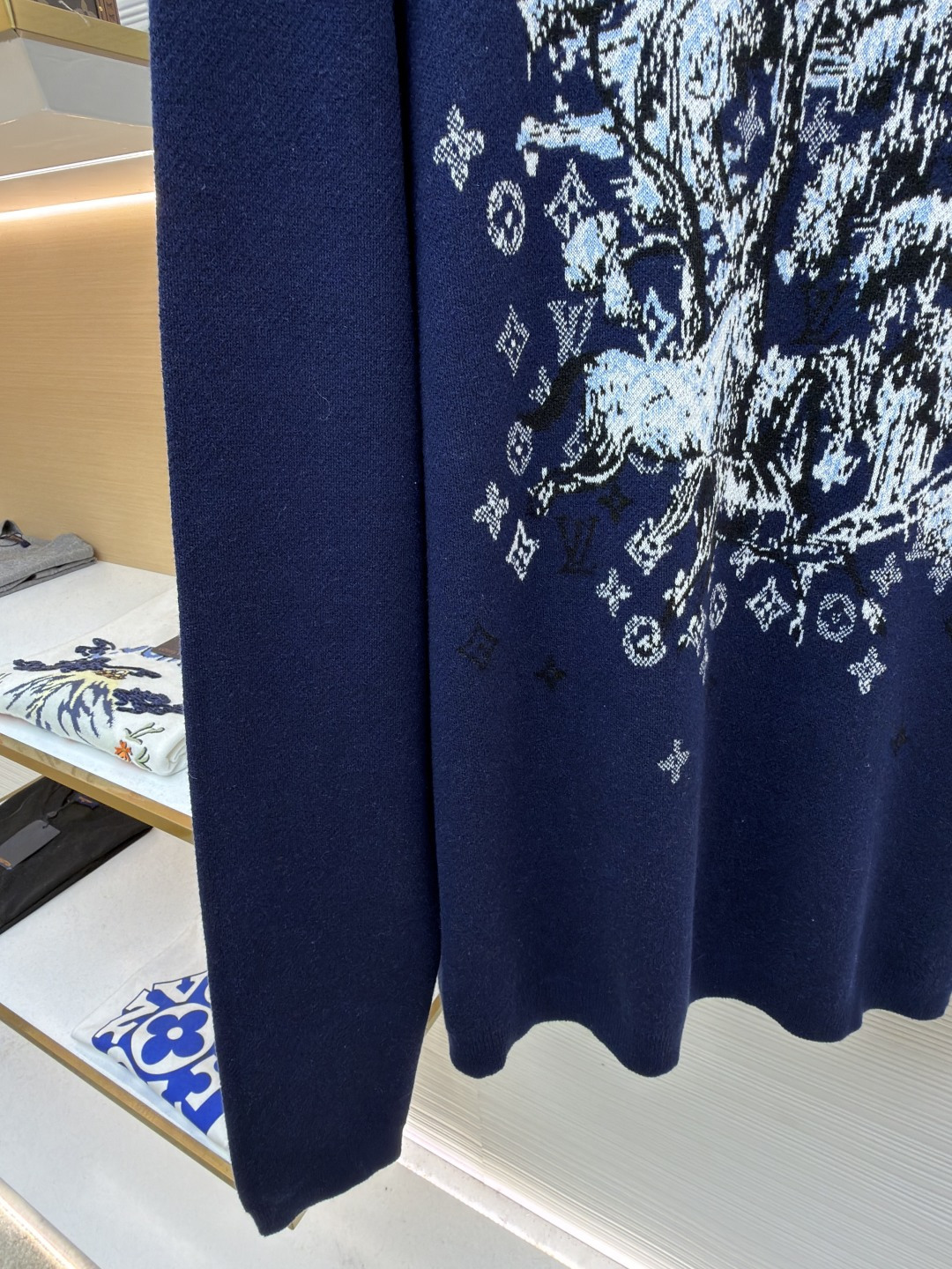 P275 LOUIS VUITTON 马年限定嵌花字母提花针织毛衣
●货号：1682611-B40
●面料：羊毛面料
●工艺：提花针织制作
●颜色：藏蓝色
●版型：合身版型
●克重：约430克
●尺码：S-M-L-XL
●描述：这款LOUIS VUITTON藏青色圆领针织衫甄选高品质羊毛混纺纱线打造，经预缩水处理后触感柔软亲肤，兼具良好的透气性与保暖性，不易起球、变形、褪色，藏青色调沉稳大气且富有质感。衣身中央的植物花卉图案采用嵌花提花工艺织造，纹理立体饱满，搭配环绕四周的品牌经典Monogram标识，通过色织工艺呈现细腻层次，视觉效果精致且富有辨识度。经典圆领采用双针加固包边，耐穿不易松垮，袖口与下摆为同色系罗纹收边，弹性适中贴合身形，整体为宽松合身廓形，肩部无缝拼接走线平直，锁边工艺精致，定制辅料与品牌标识细节齐全，适配日常休闲、轻商务等多种穿搭场景，是打造简约高级造型的时尚单品。整体走线平直细腻，面料舒适柔软，颜色一致无色差 能与同款搭配营造时尚造型，驾驭各种场合，定制辅料，三标齐全，男女同款！