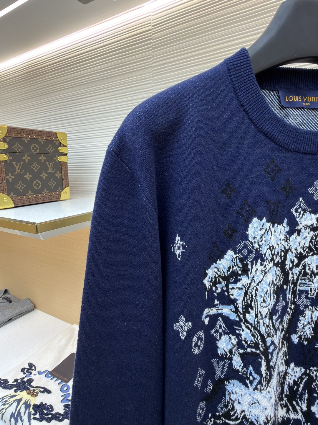P275 LOUIS VUITTON 马年限定嵌花字母提花针织毛衣
●货号：1682611-B40
●面料：羊毛面料
●工艺：提花针织制作
●颜色：藏蓝色
●版型：合身版型
●克重：约430克
●尺码：S-M-L-XL
●描述：这款LOUIS VUITTON藏青色圆领针织衫甄选高品质羊毛混纺纱线打造，经预缩水处理后触感柔软亲肤，兼具良好的透气性与保暖性，不易起球、变形、褪色，藏青色调沉稳大气且富有质感。衣身中央的植物花卉图案采用嵌花提花工艺织造，纹理立体饱满，搭配环绕四周的品牌经典Monogram标识，通过色织工艺呈现细腻层次，视觉效果精致且富有辨识度。经典圆领采用双针加固包边，耐穿不易松垮，袖口与下摆为同色系罗纹收边，弹性适中贴合身形，整体为宽松合身廓形，肩部无缝拼接走线平直，锁边工艺精致，定制辅料与品牌标识细节齐全，适配日常休闲、轻商务等多种穿搭场景，是打造简约高级造型的时尚单品。整体走线平直细腻，面料舒适柔软，颜色一致无色差 能与同款搭配营造时尚造型，驾驭各种场合，定制辅料，三标齐全，男女同款！