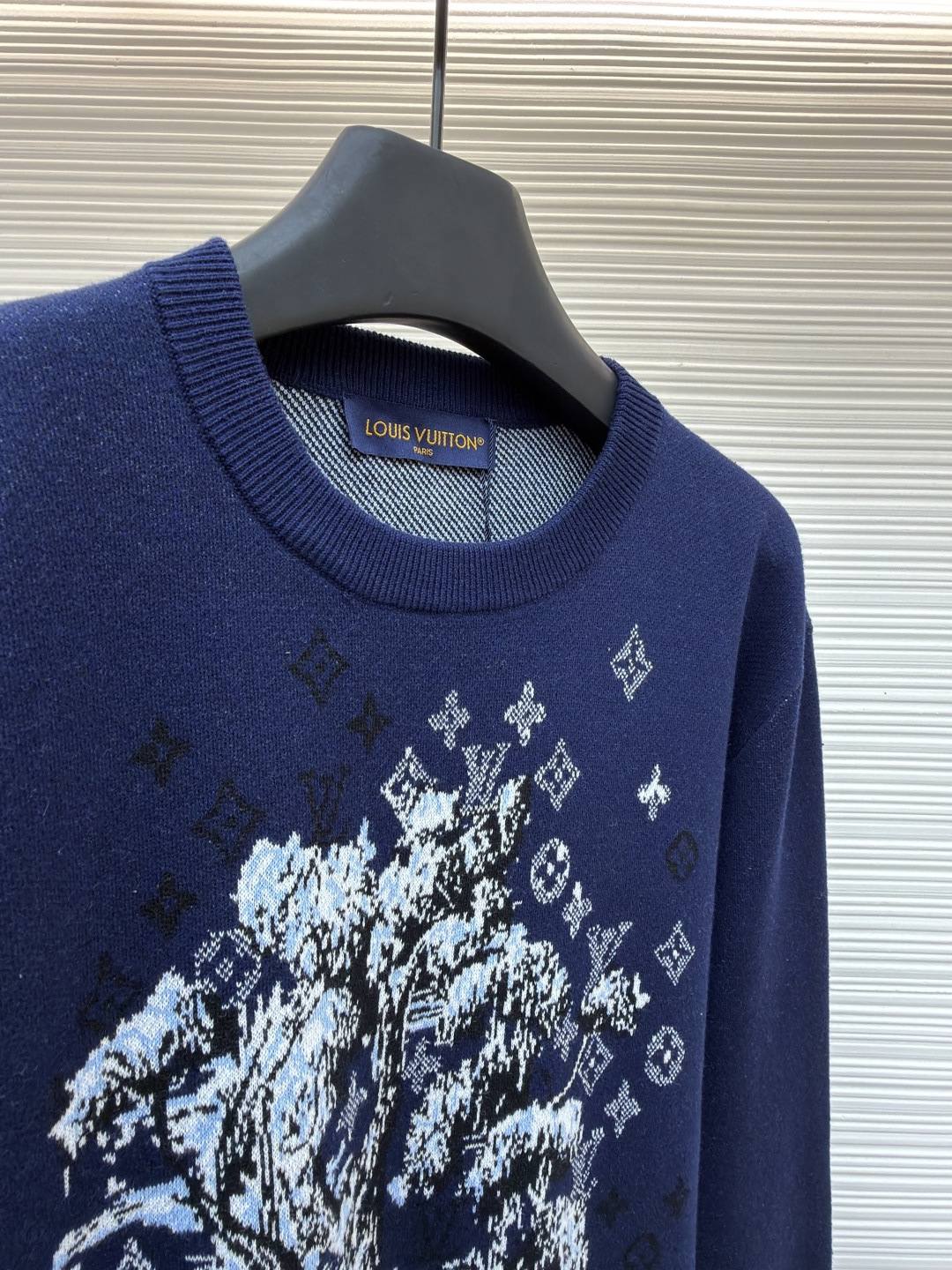P275 LOUIS VUITTON 马年限定嵌花字母提花针织毛衣
●货号：1682611-B40
●面料：羊毛面料
●工艺：提花针织制作
●颜色：藏蓝色
●版型：合身版型
●克重：约430克
●尺码：S-M-L-XL
●描述：这款LOUIS VUITTON藏青色圆领针织衫甄选高品质羊毛混纺纱线打造，经预缩水处理后触感柔软亲肤，兼具良好的透气性与保暖性，不易起球、变形、褪色，藏青色调沉稳大气且富有质感。衣身中央的植物花卉图案采用嵌花提花工艺织造，纹理立体饱满，搭配环绕四周的品牌经典Monogram标识，通过色织工艺呈现细腻层次，视觉效果精致且富有辨识度。经典圆领采用双针加固包边，耐穿不易松垮，袖口与下摆为同色系罗纹收边，弹性适中贴合身形，整体为宽松合身廓形，肩部无缝拼接走线平直，锁边工艺精致，定制辅料与品牌标识细节齐全，适配日常休闲、轻商务等多种穿搭场景，是打造简约高级造型的时尚单品。整体走线平直细腻，面料舒适柔软，颜色一致无色差 能与同款搭配营造时尚造型，驾驭各种场合，定制辅料，三标齐全，男女同款！