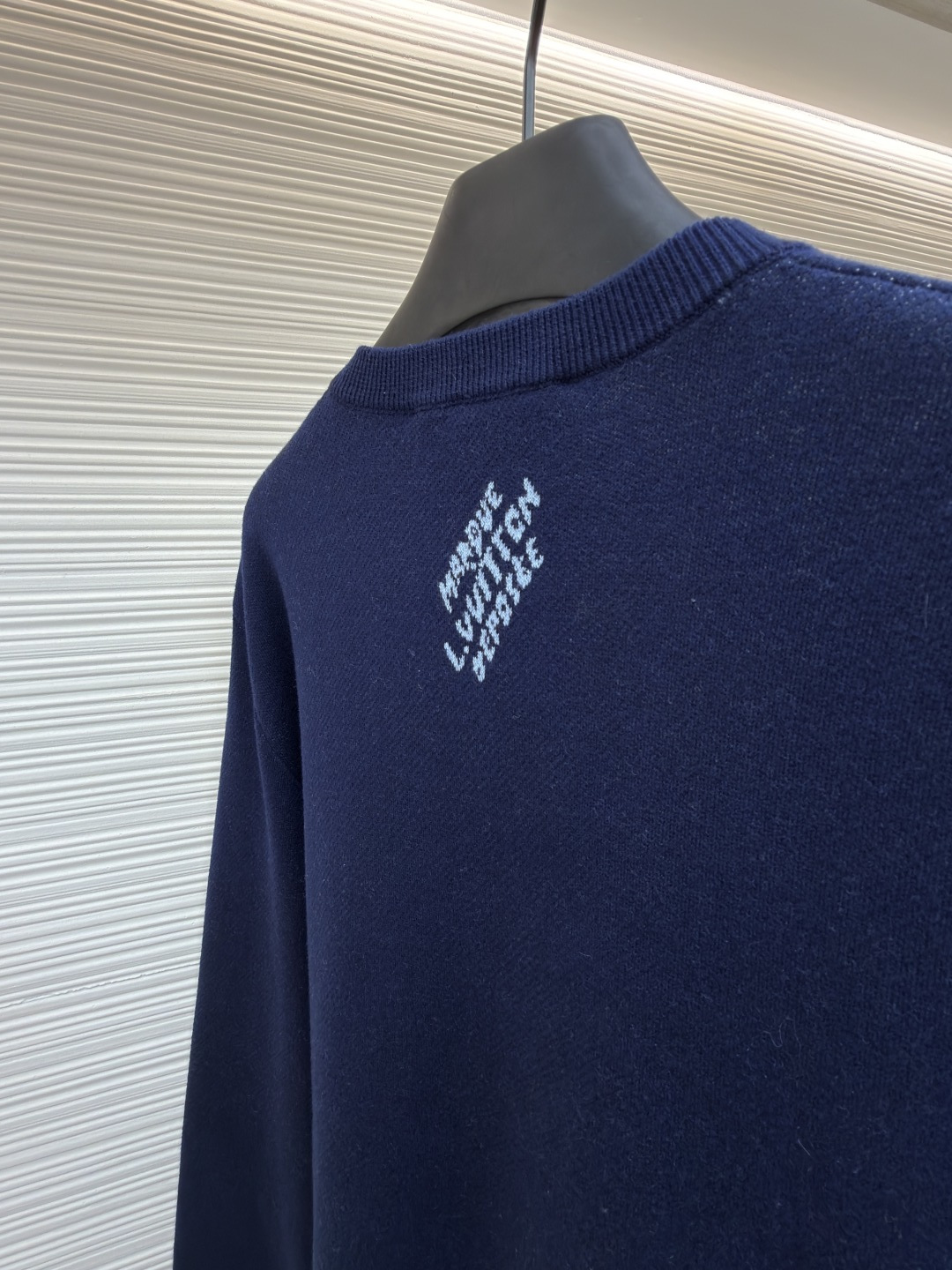 P275 LOUIS VUITTON 马年限定嵌花字母提花针织毛衣
●货号：1682611-B40
●面料：羊毛面料
●工艺：提花针织制作
●颜色：藏蓝色
●版型：合身版型
●克重：约430克
●尺码：S-M-L-XL
●描述：这款LOUIS VUITTON藏青色圆领针织衫甄选高品质羊毛混纺纱线打造，经预缩水处理后触感柔软亲肤，兼具良好的透气性与保暖性，不易起球、变形、褪色，藏青色调沉稳大气且富有质感。衣身中央的植物花卉图案采用嵌花提花工艺织造，纹理立体饱满，搭配环绕四周的品牌经典Monogram标识，通过色织工艺呈现细腻层次，视觉效果精致且富有辨识度。经典圆领采用双针加固包边，耐穿不易松垮，袖口与下摆为同色系罗纹收边，弹性适中贴合身形，整体为宽松合身廓形，肩部无缝拼接走线平直，锁边工艺精致，定制辅料与品牌标识细节齐全，适配日常休闲、轻商务等多种穿搭场景，是打造简约高级造型的时尚单品。整体走线平直细腻，面料舒适柔软，颜色一致无色差 能与同款搭配营造时尚造型，驾驭各种场合，定制辅料，三标齐全，男女同款！