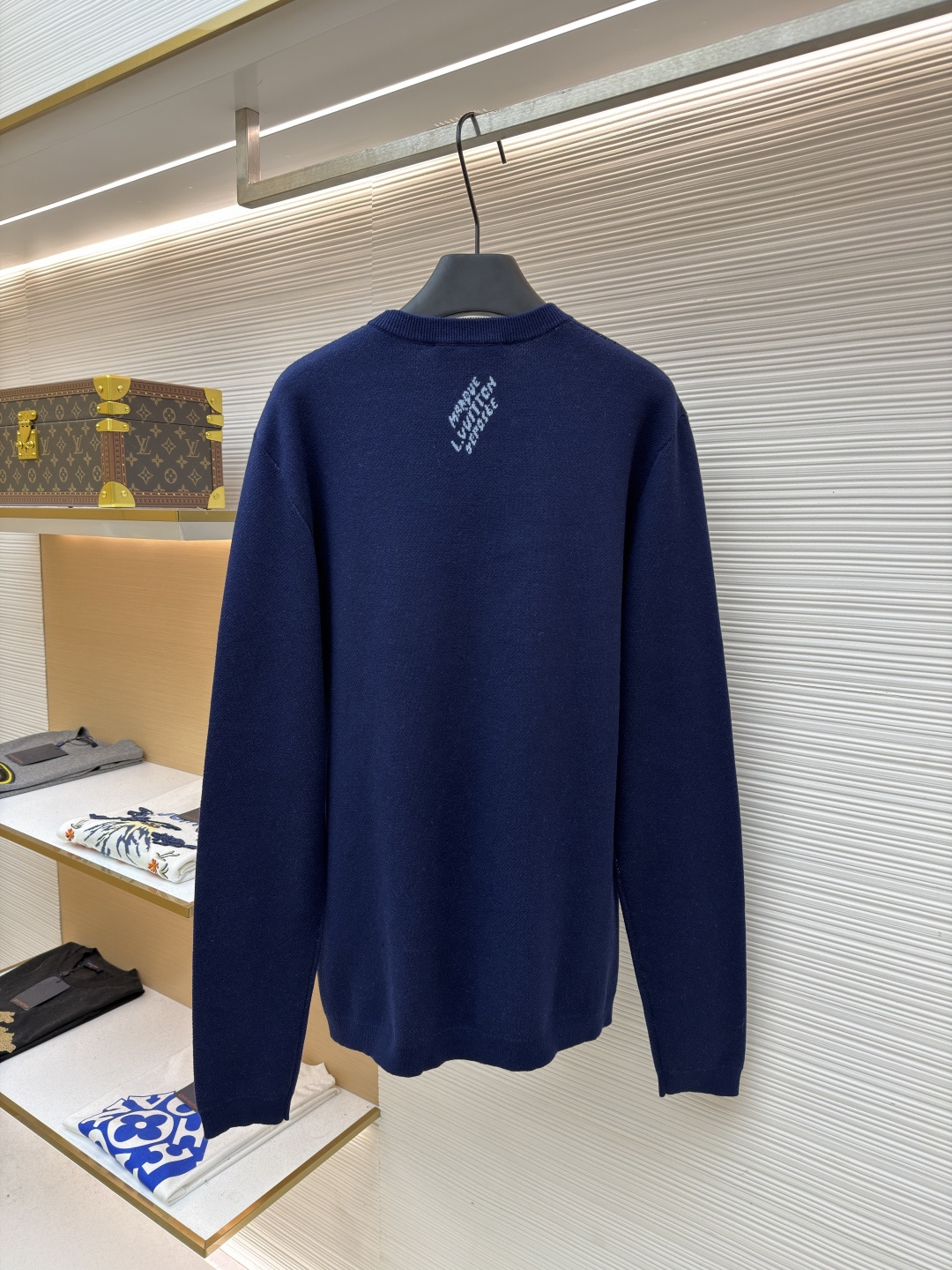 P275 LOUIS VUITTON 马年限定嵌花字母提花针织毛衣
●货号：1682611-B40
●面料：羊毛面料
●工艺：提花针织制作
●颜色：藏蓝色
●版型：合身版型
●克重：约430克
●尺码：S-M-L-XL
●描述：这款LOUIS VUITTON藏青色圆领针织衫甄选高品质羊毛混纺纱线打造，经预缩水处理后触感柔软亲肤，兼具良好的透气性与保暖性，不易起球、变形、褪色，藏青色调沉稳大气且富有质感。衣身中央的植物花卉图案采用嵌花提花工艺织造，纹理立体饱满，搭配环绕四周的品牌经典Monogram标识，通过色织工艺呈现细腻层次，视觉效果精致且富有辨识度。经典圆领采用双针加固包边，耐穿不易松垮，袖口与下摆为同色系罗纹收边，弹性适中贴合身形，整体为宽松合身廓形，肩部无缝拼接走线平直，锁边工艺精致，定制辅料与品牌标识细节齐全，适配日常休闲、轻商务等多种穿搭场景，是打造简约高级造型的时尚单品。整体走线平直细腻，面料舒适柔软，颜色一致无色差 能与同款搭配营造时尚造型，驾驭各种场合，定制辅料，三标齐全，男女同款！